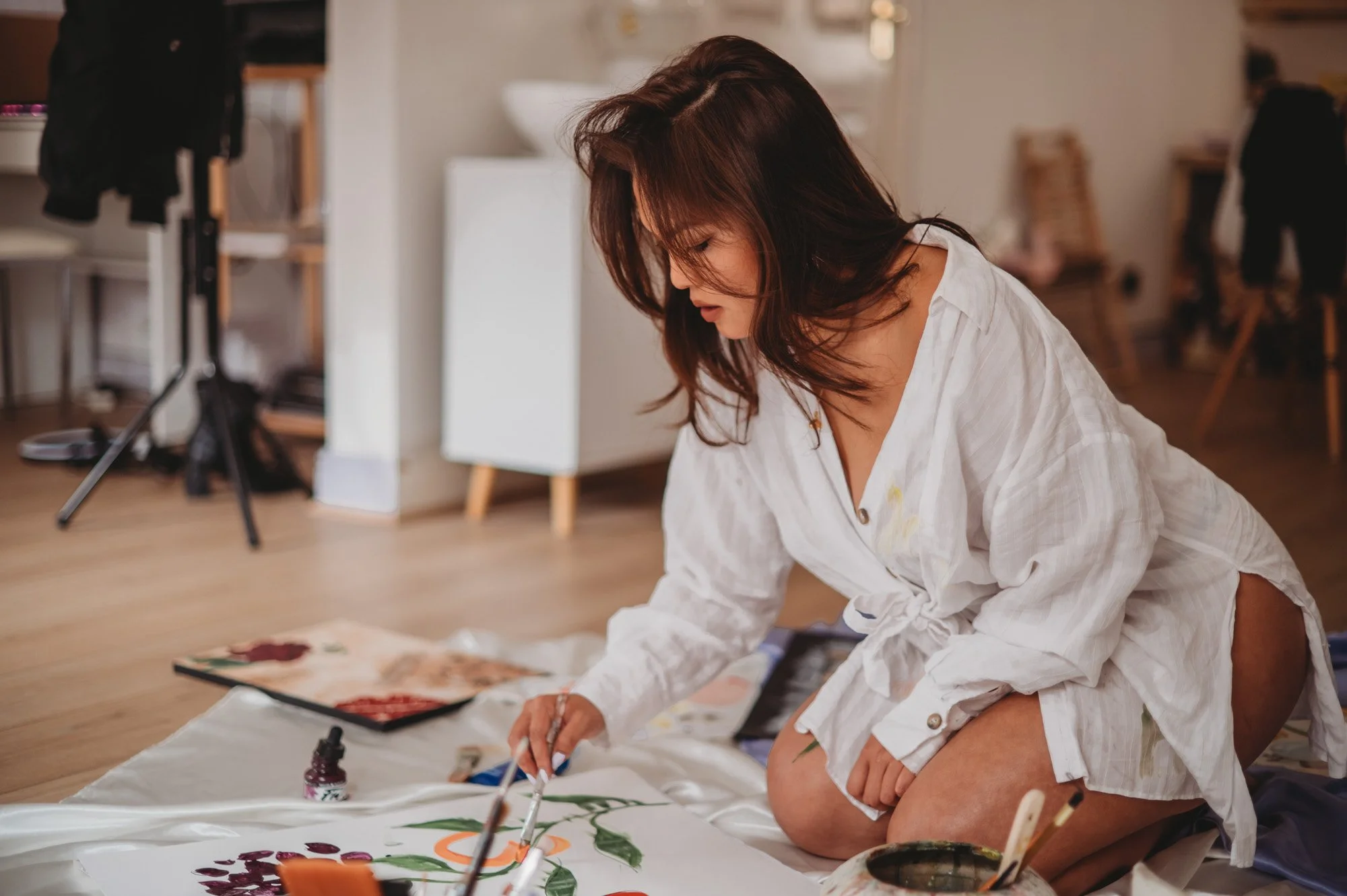 Artist Erica Pham painting an abstract piece in the studio.