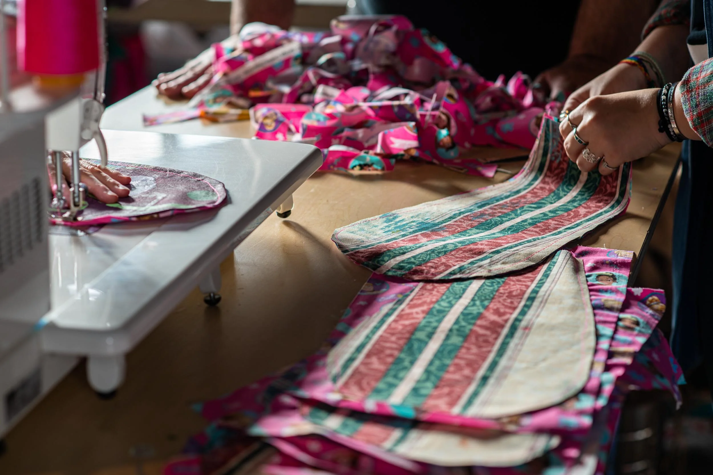 Patty Mitchell (left) stitches fabric petals for a skirt with the help of Logan Madison (right) to prepare for the Honey for the Heart parade in Athens, Ohio, Thursday, October 24, 2019. Though many of the costumes are made of papier-mâché, an effort