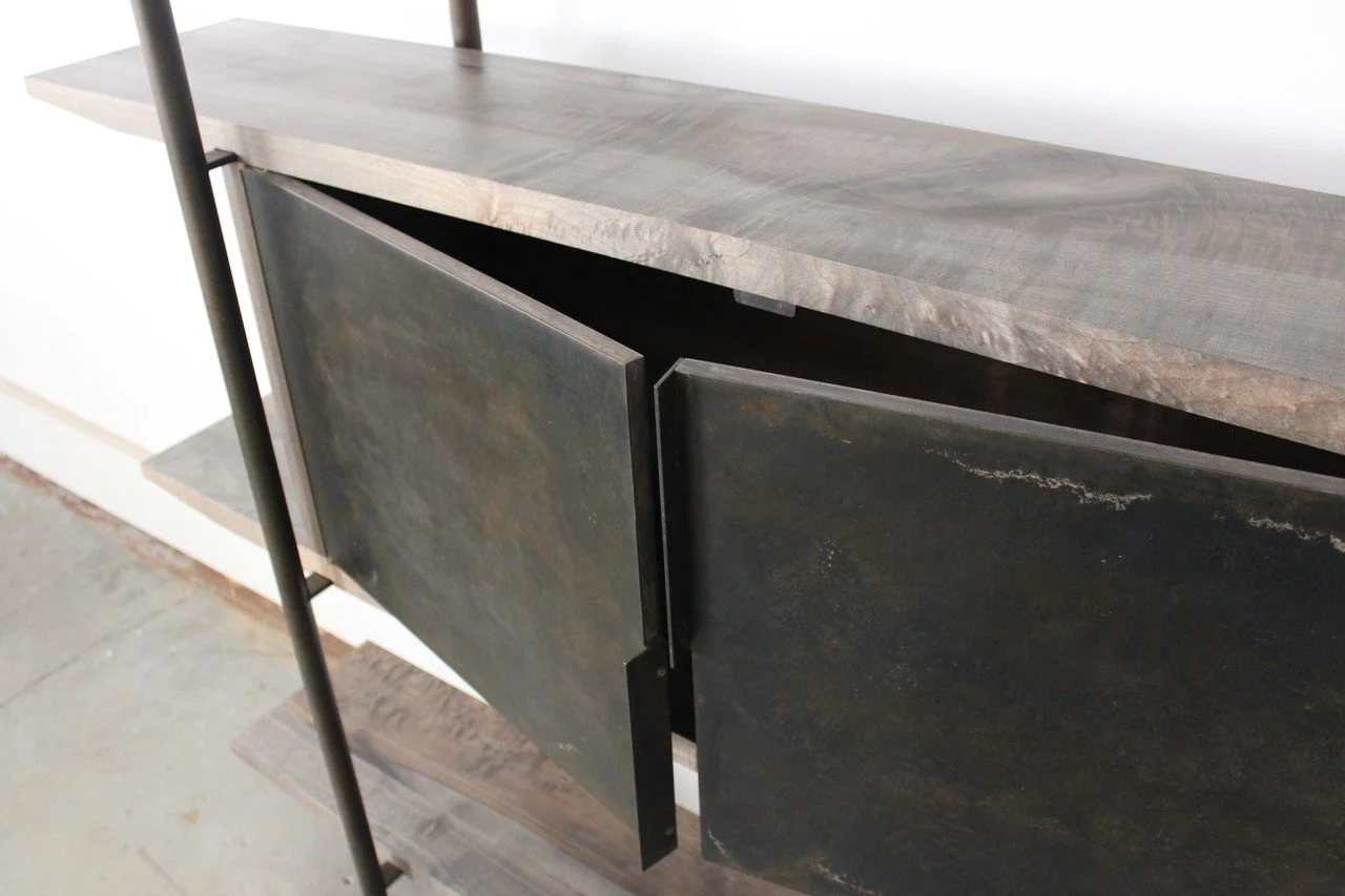 Close-up of a modern wooden and metal cabinet with sliding doors in a minimalist setting.