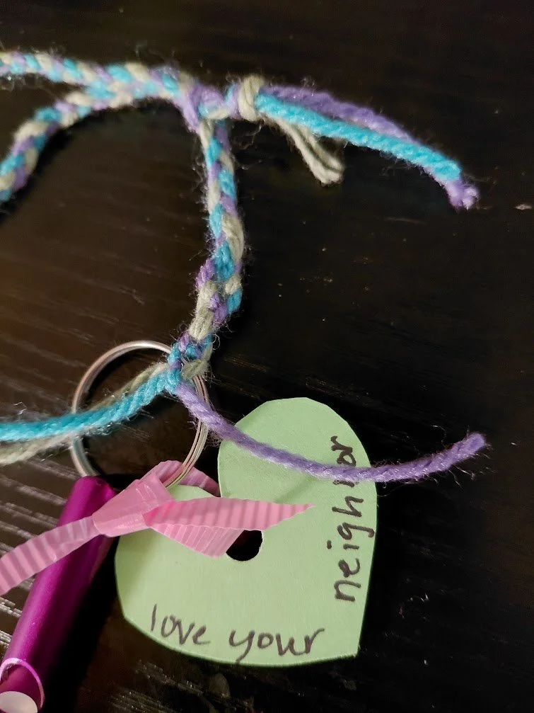 The braided yarn, shown with the purple "love your neighbor" whistle.