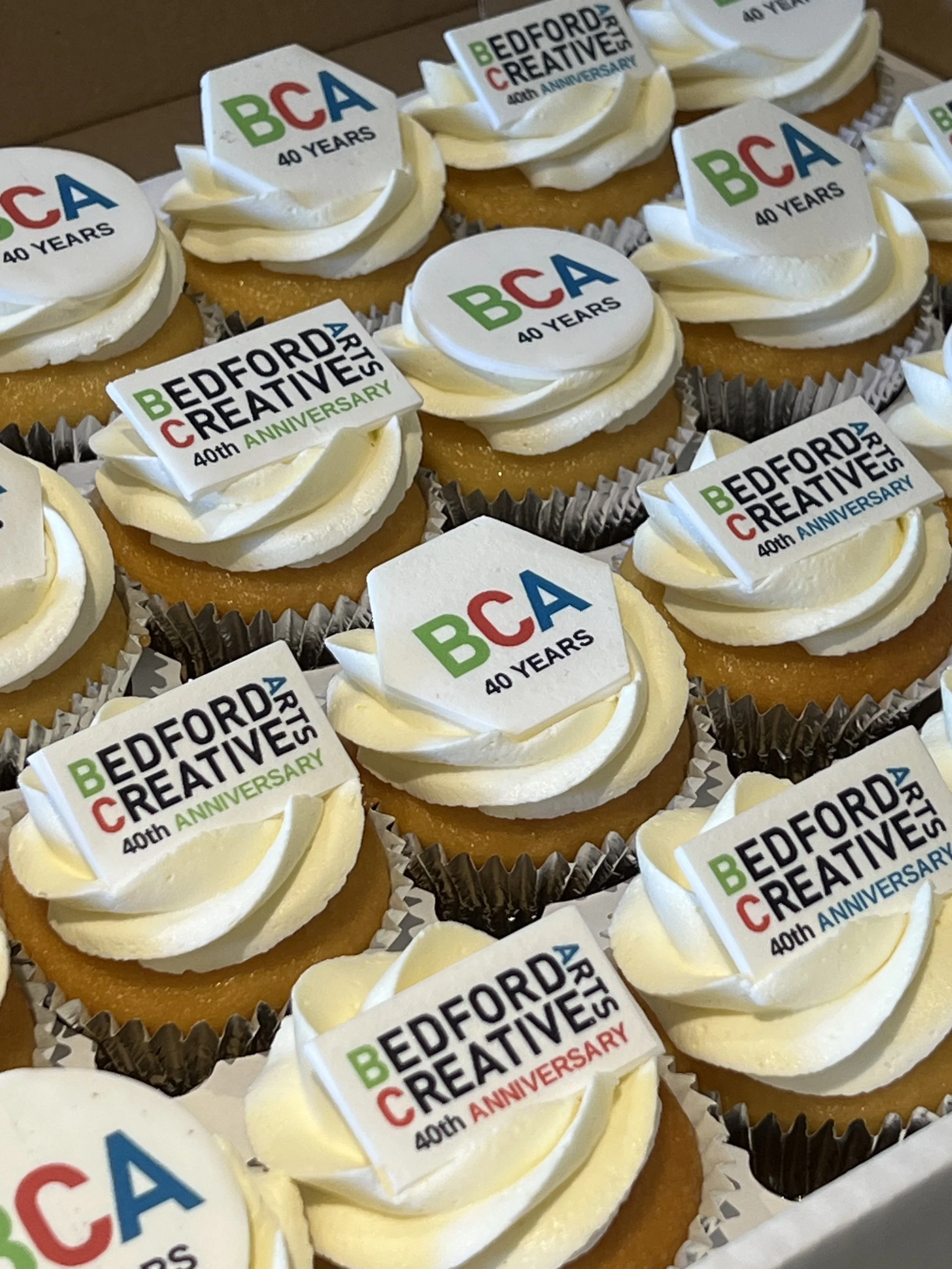 Custom corporate logo toppers on cupcakes.