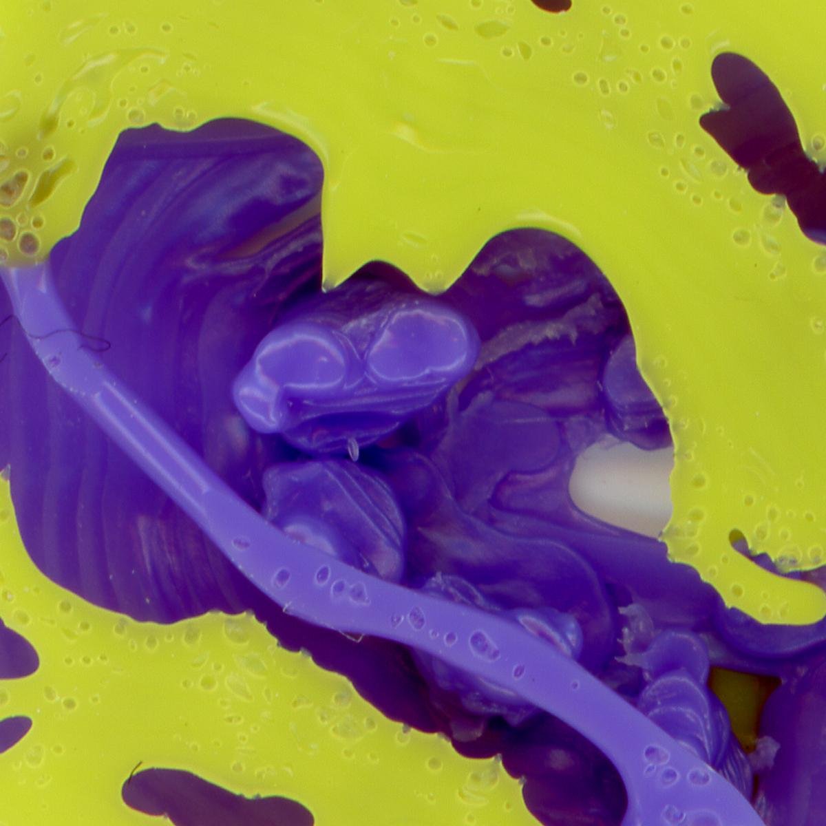 Vivid blue and yellow plastic melted together in uneven shapes showing bubbles and striations