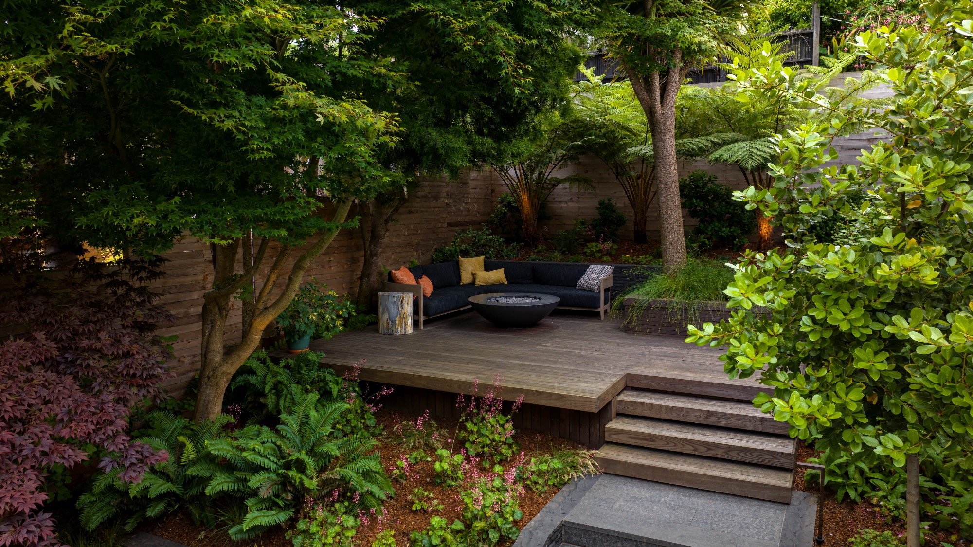 Wood deck lounge with firepit and lush naturalistic planting in San Francisco
