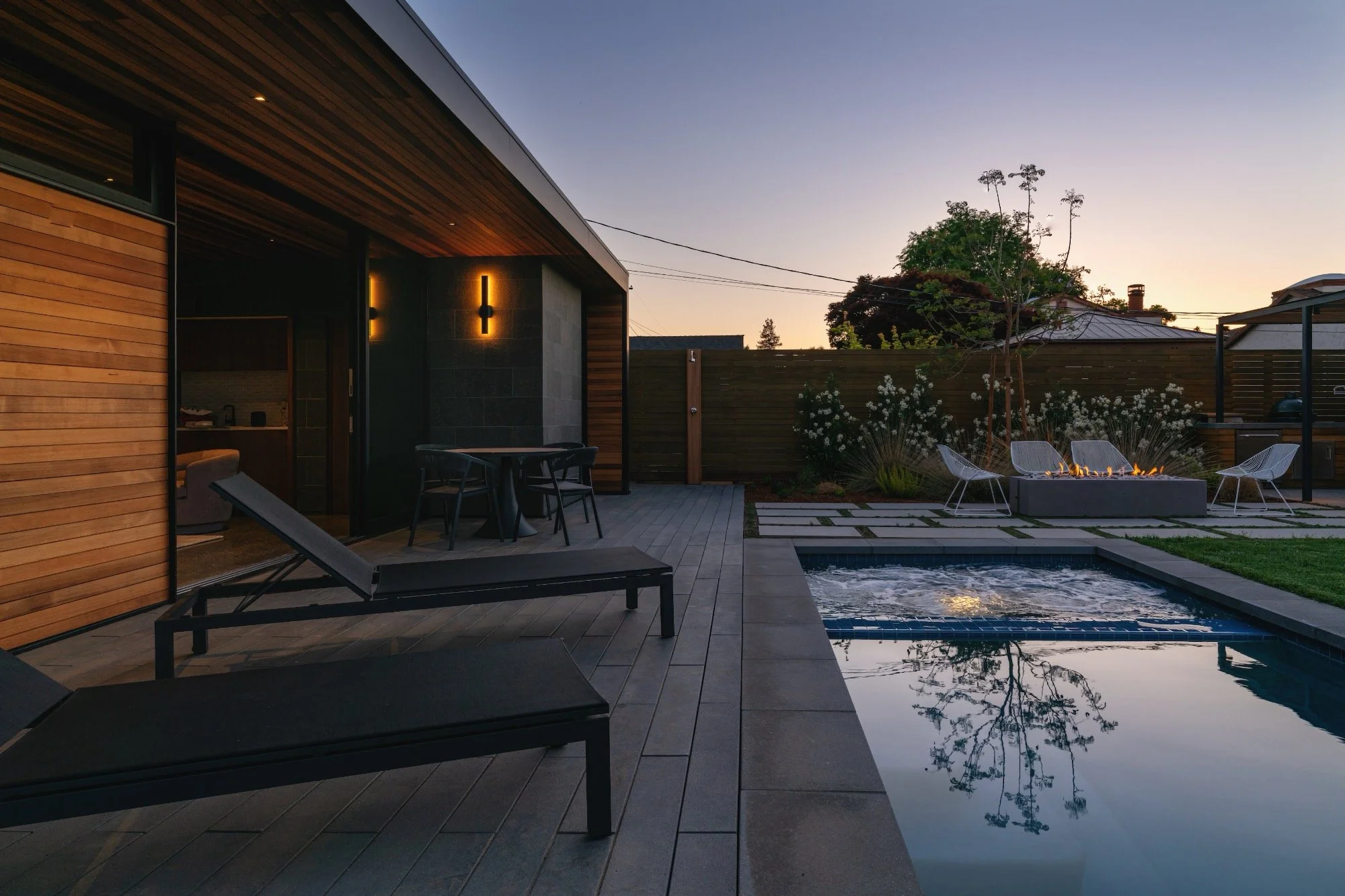 Pool with spa next to a modern ADU just after sunset in San Jose