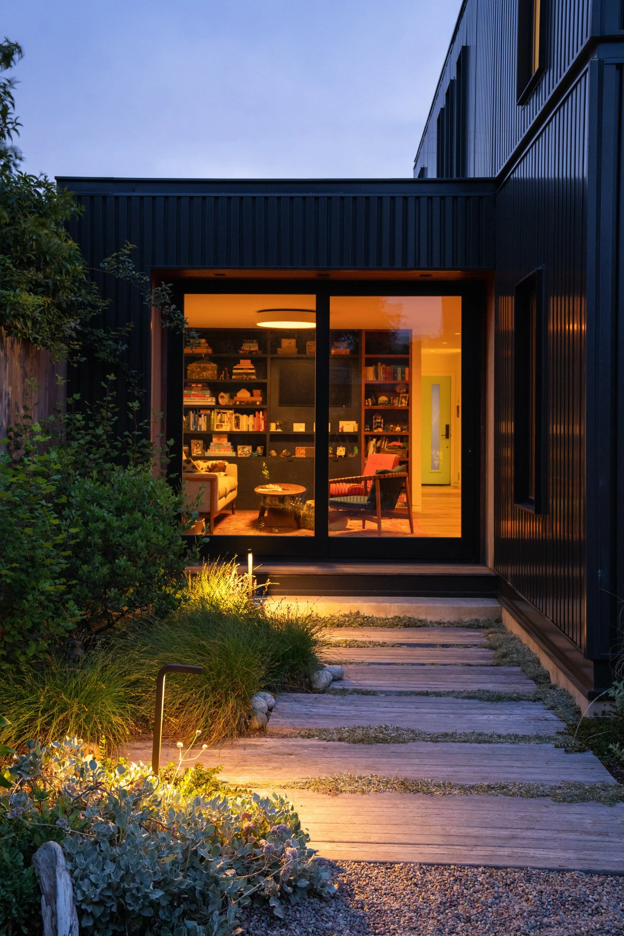 Timber pathway to interior living room at night