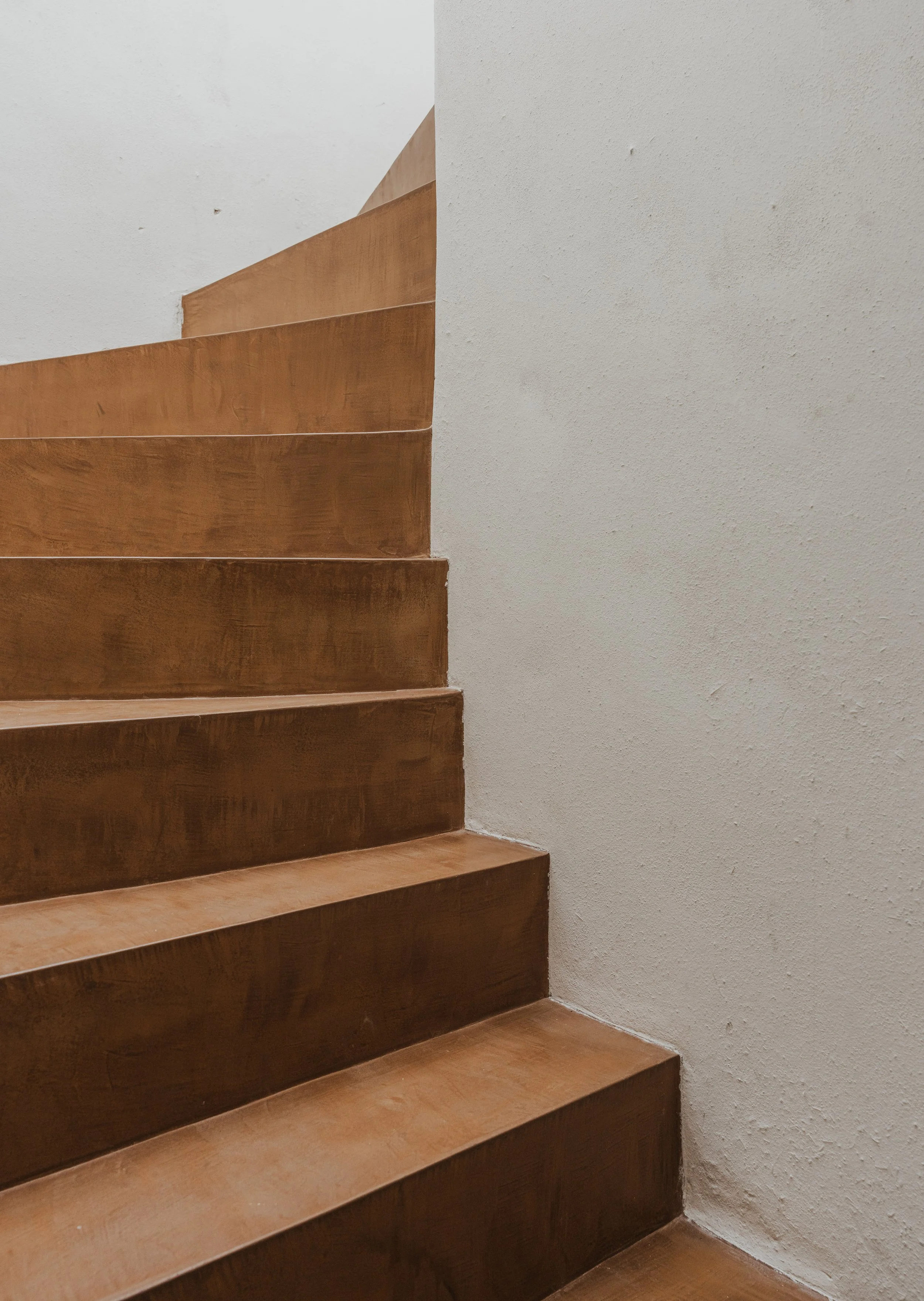 Wooden staircase with a white wall on the side