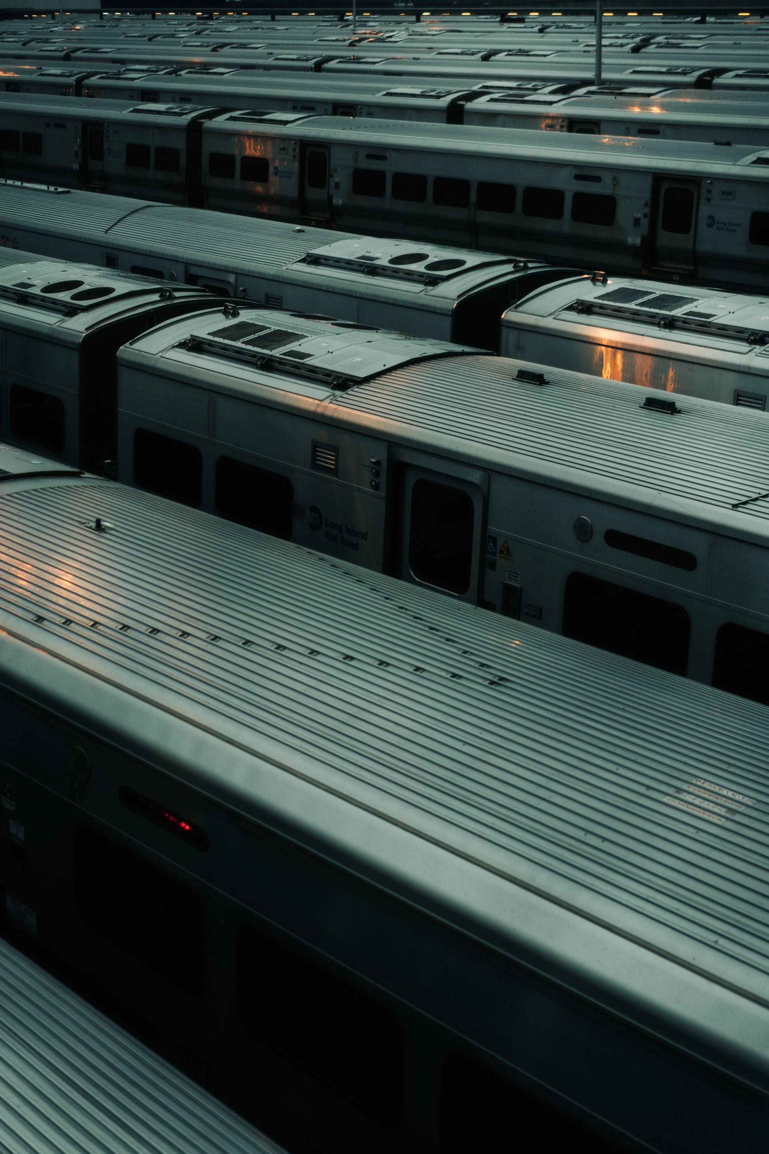 Multiple steel train cars parked side by side at a train yard.