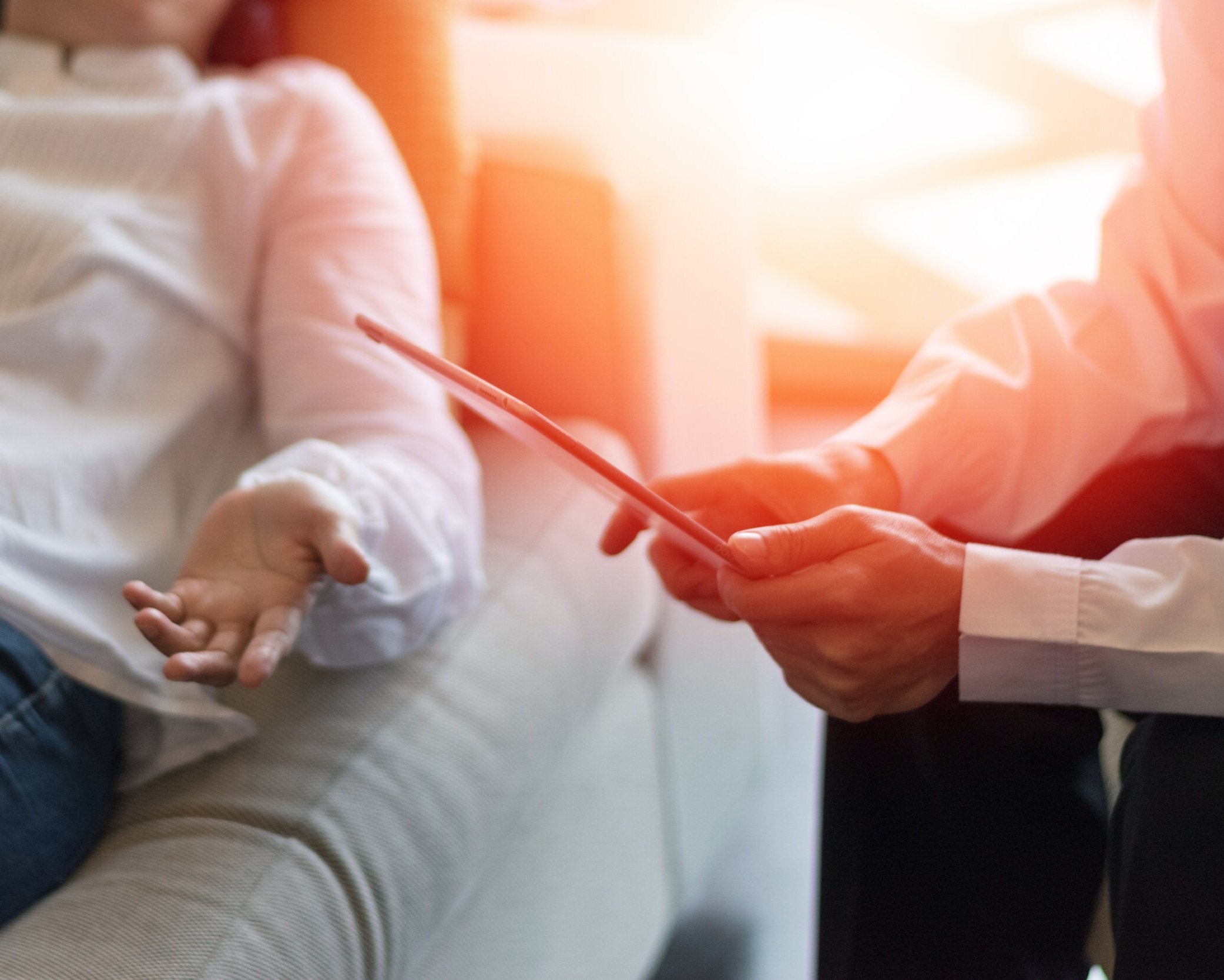 Therapist taking notes during a counseling session with a client reclining on a couch in a calm, sunlit office, representing professional mental health support for anxiety, depression, relationships, and emotional wellbeing.