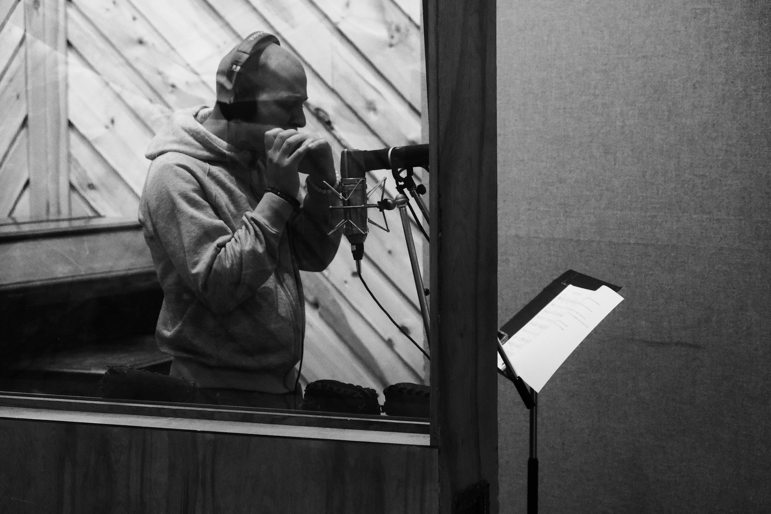 Musician recording in studio with a harmonica