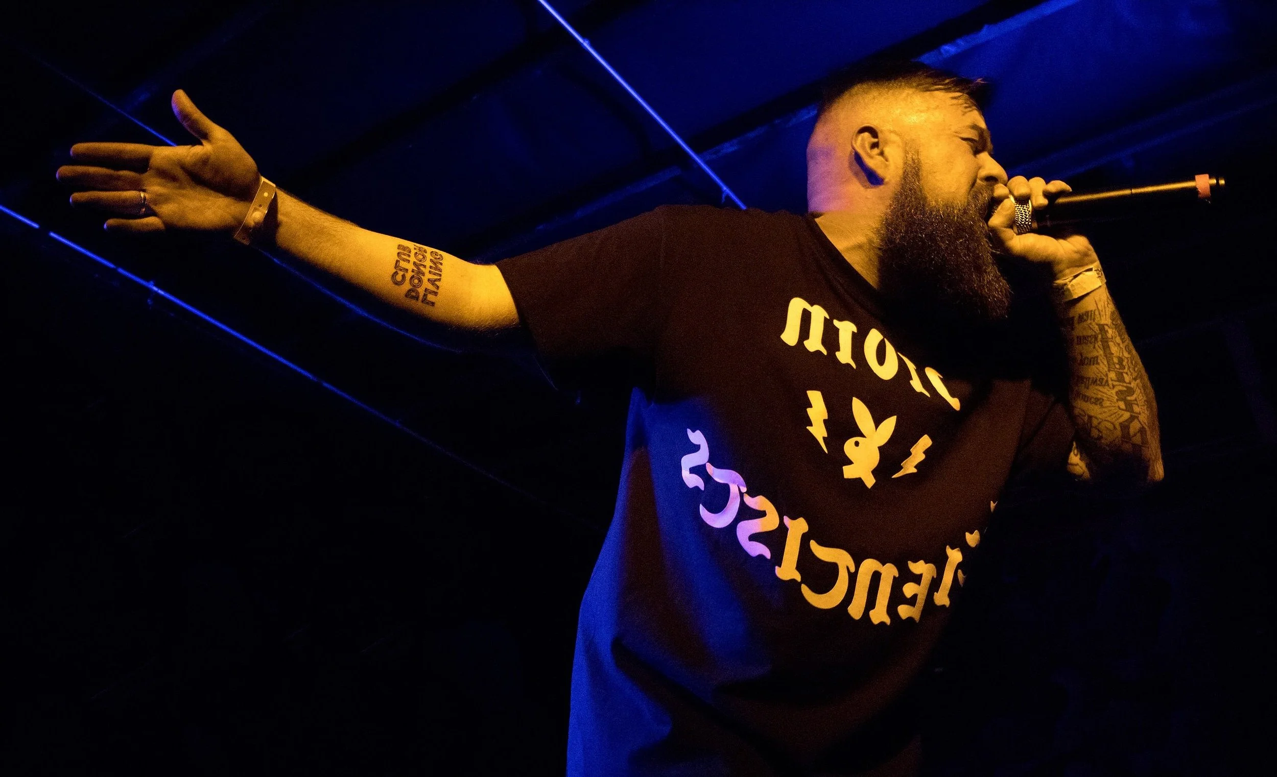 Facade of a building with a wooden door, window, a white bicycle leaning against the wall, and a wall-mounted lantern.