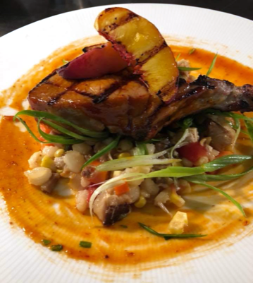 Grilled Pork Chop, hominy ragu with peaches and honey chipotle bbq sauce