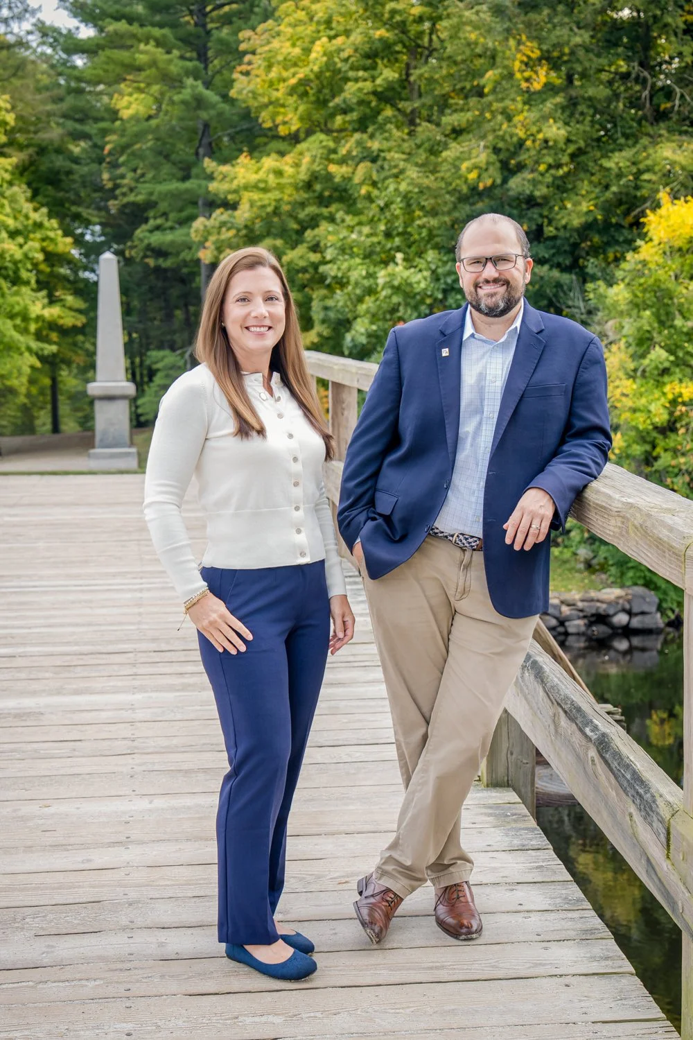 Tom Matthews and Joanne Taranto of the Tom and Joanne Team standing on the Old North Bridge in Concord, MA.  Theywho specialize in selling Concord, Massachusetts luxury real estate.