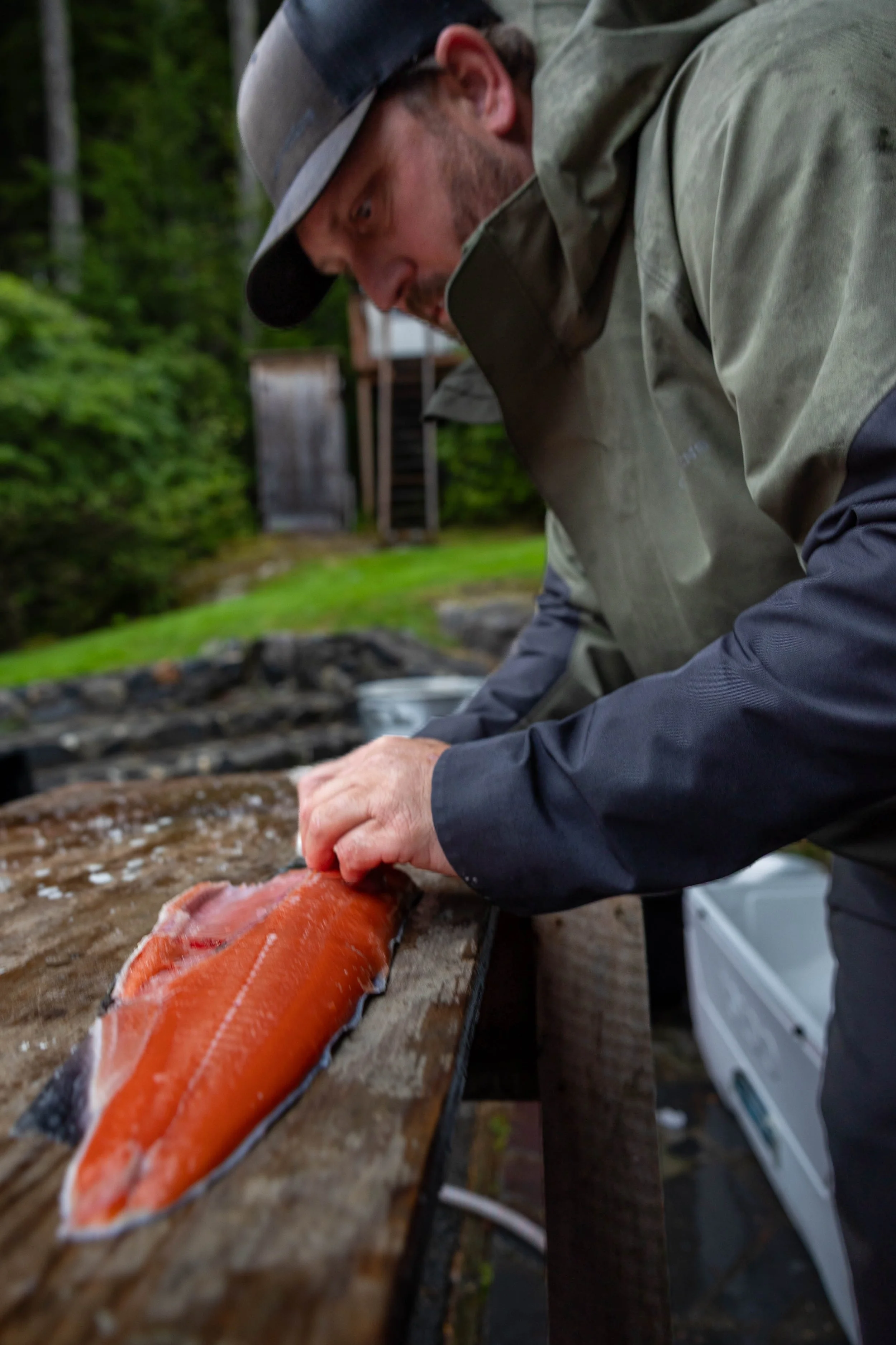Rick at the Lodge in Wrangell filleting a bright red silver salmon during the Fall Fishing a Foraging Program.