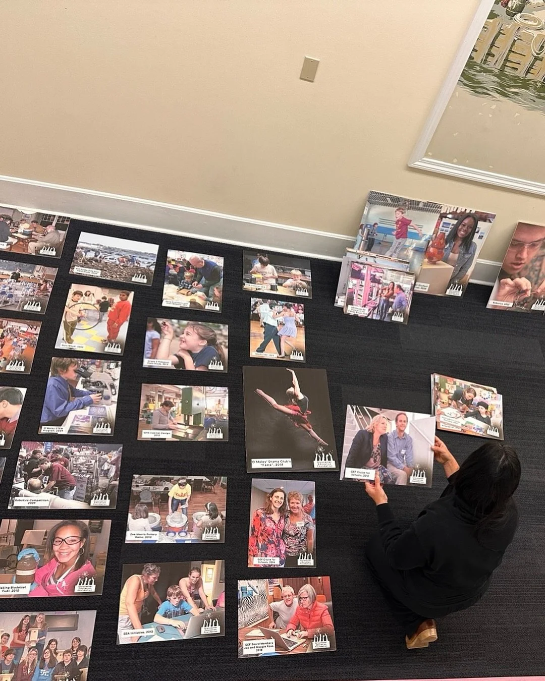 So fun to watch GEF volunteer and interior designer Rochelle Grenier of @soughtinteriors lay out our photo gallery for the gala today! 20 years of GEF in pictures&hellip;we can&rsquo;t wait to hang this at @cruiseportgloucester on Thursday!