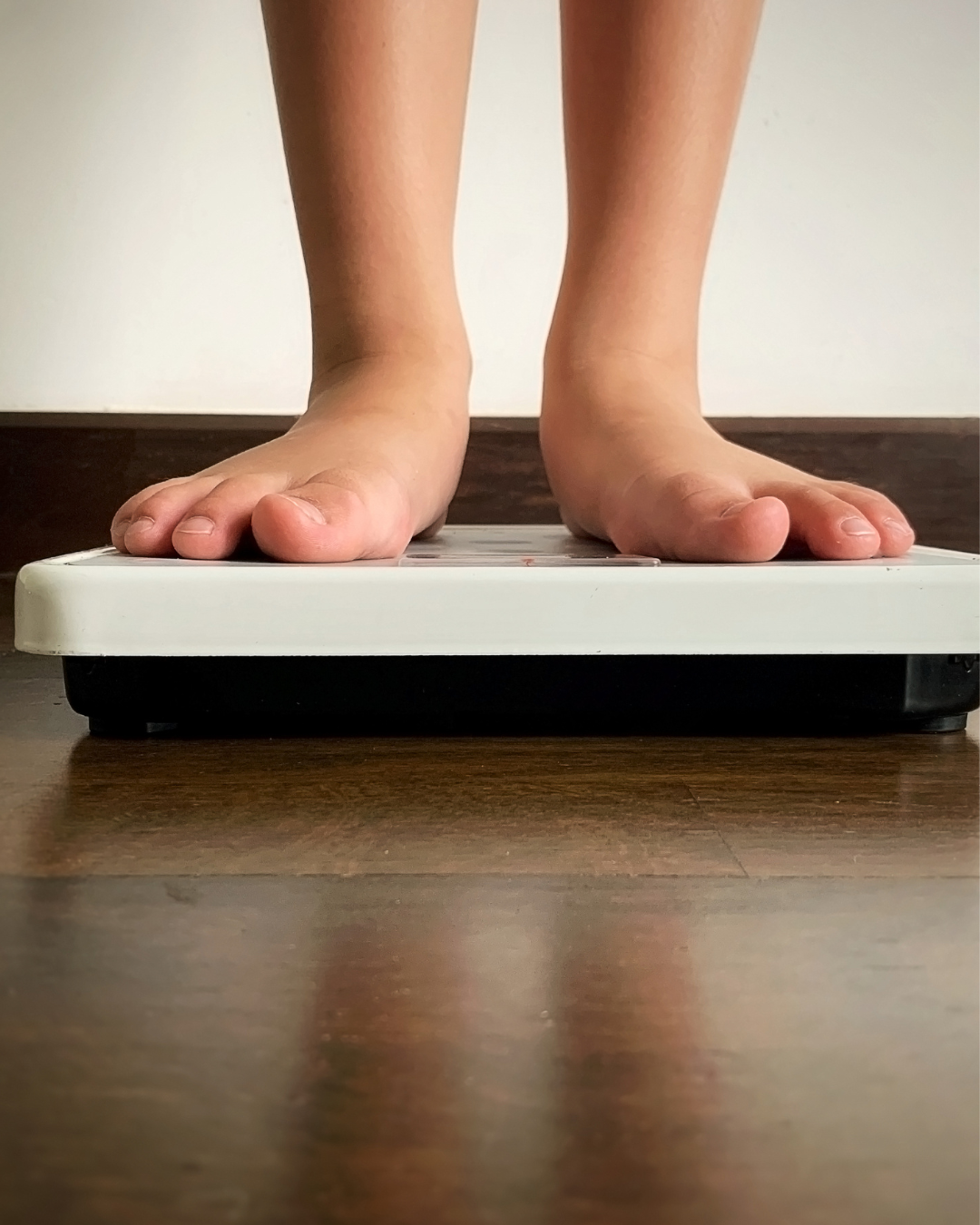 child standing on scale only feet are visible