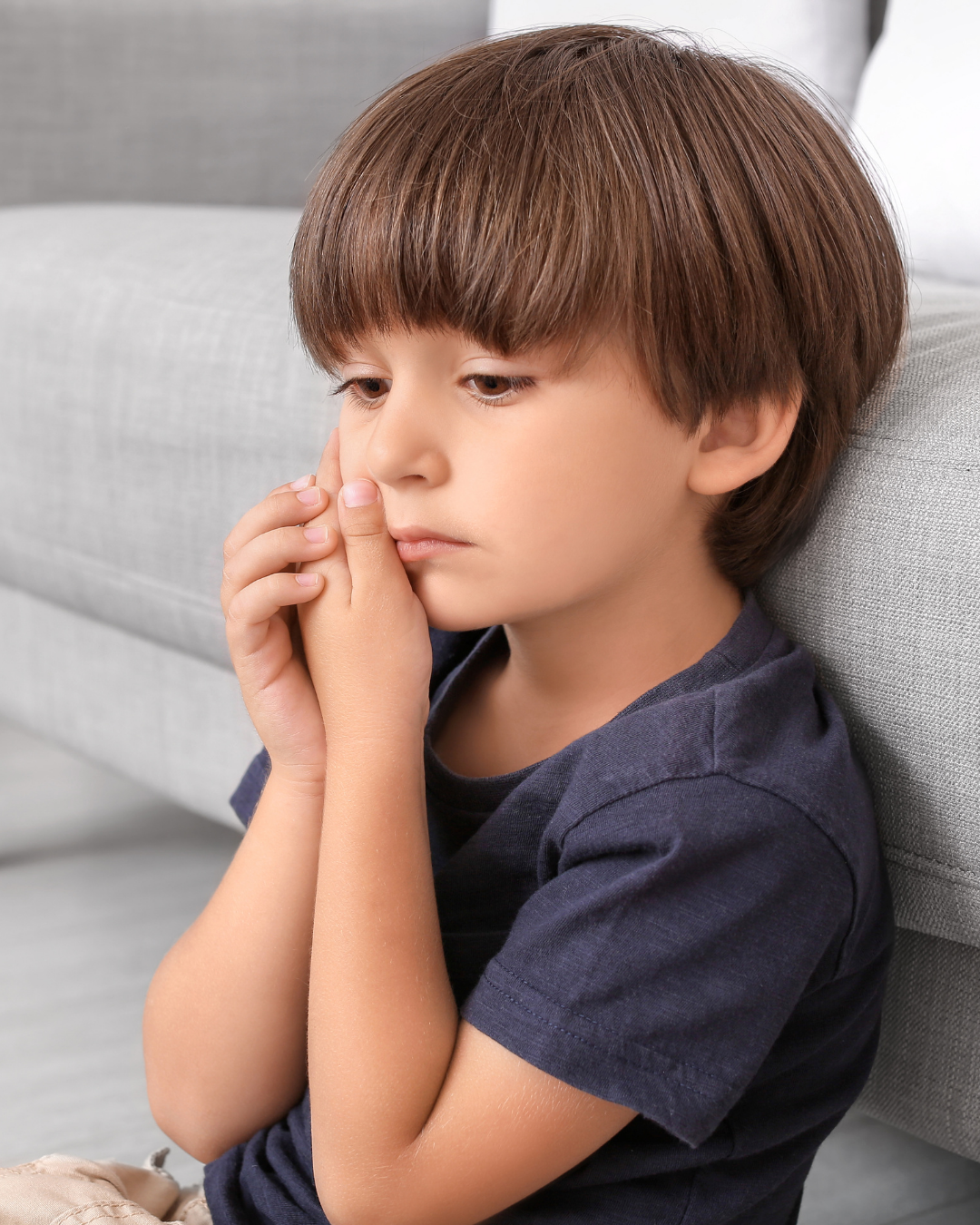 child holding cheek / ear in pain