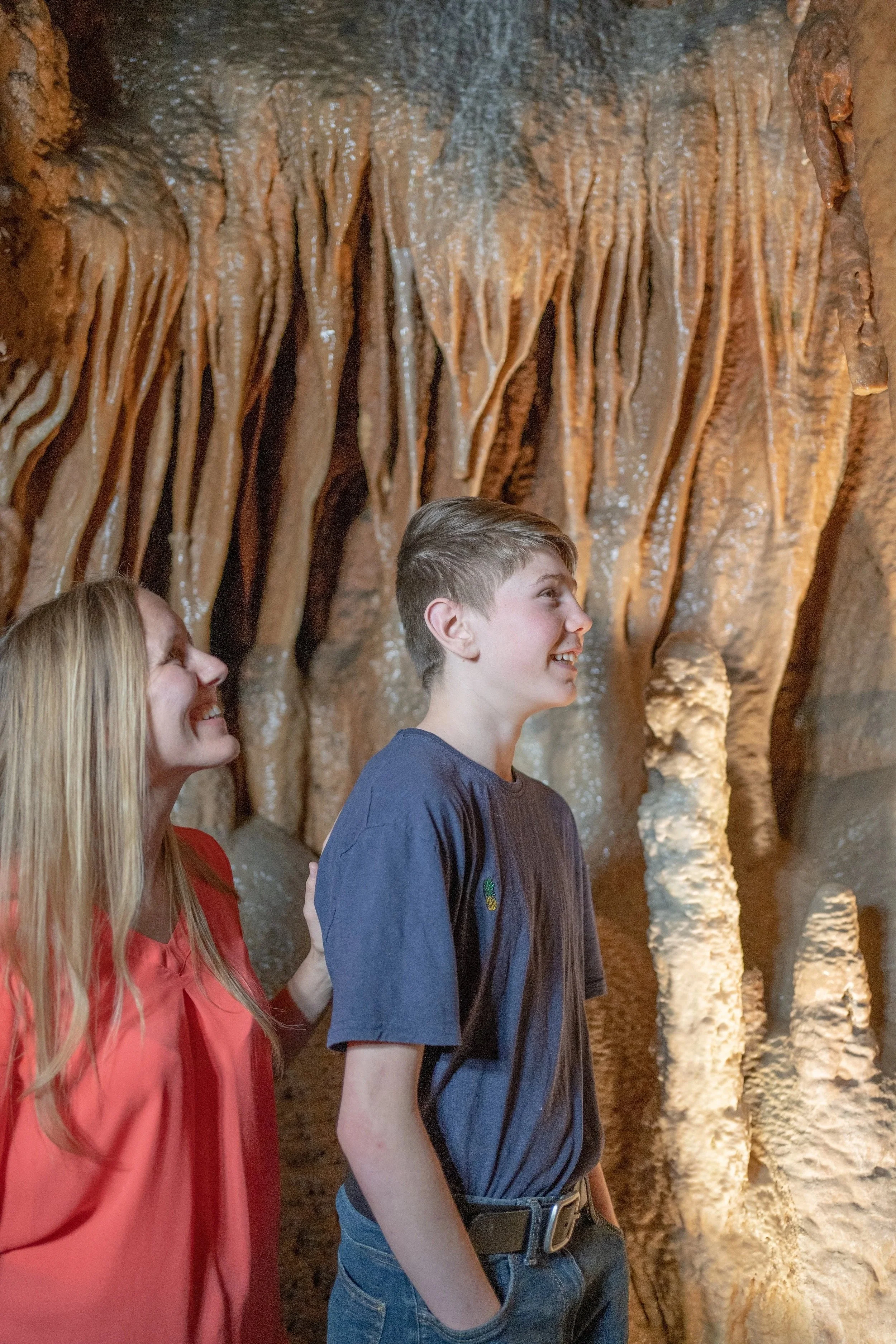 Mother and son smiling walking through a cave