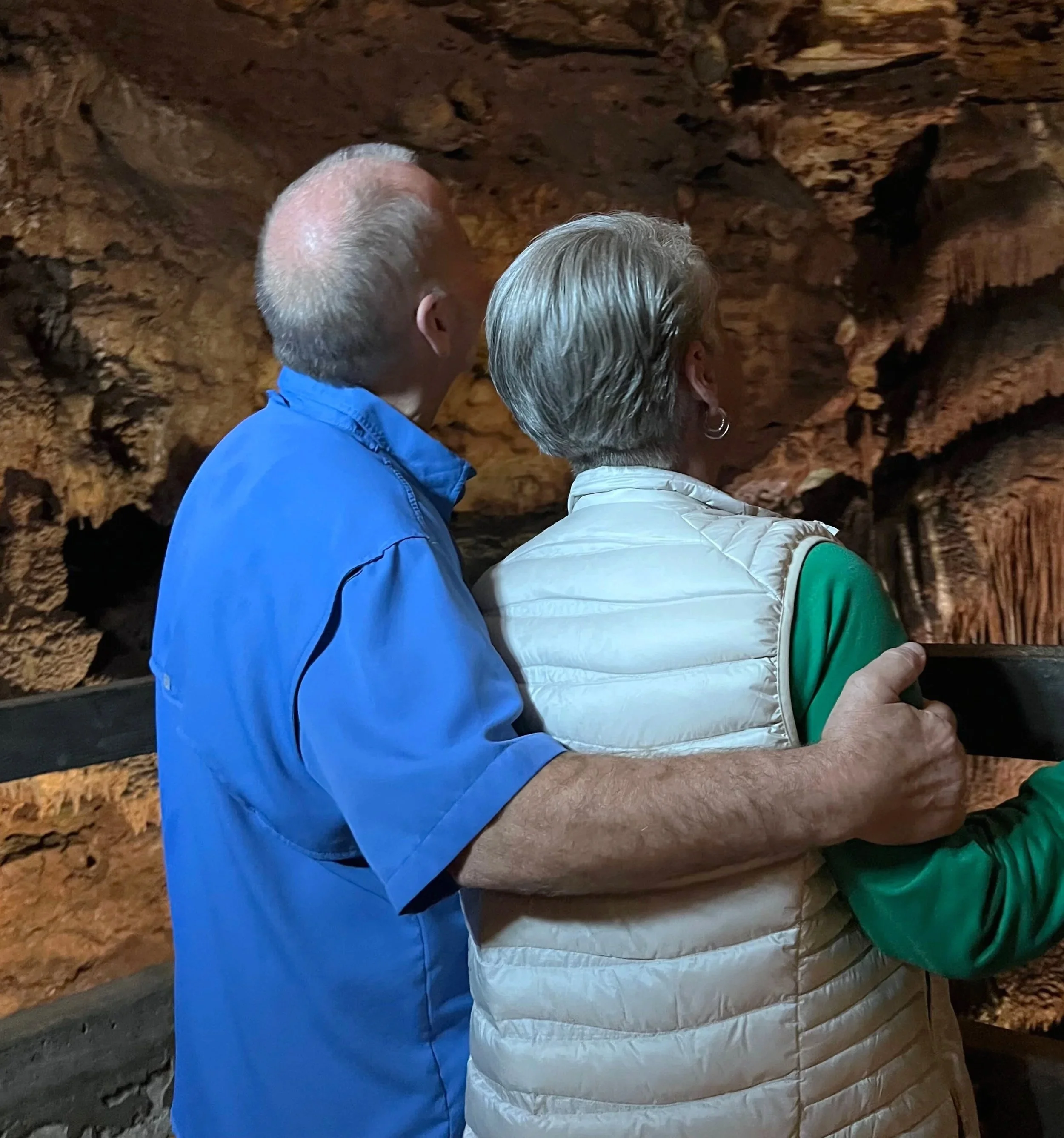 Man and Woman standing inside cave looking at formations