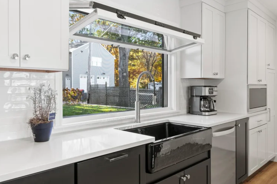 full-service-interior-design-bristol-ri-natural-vs-engineered-stone-countertops-kitchen-with-white-cabinets-black-farmhouse-sink-high-contrast.png