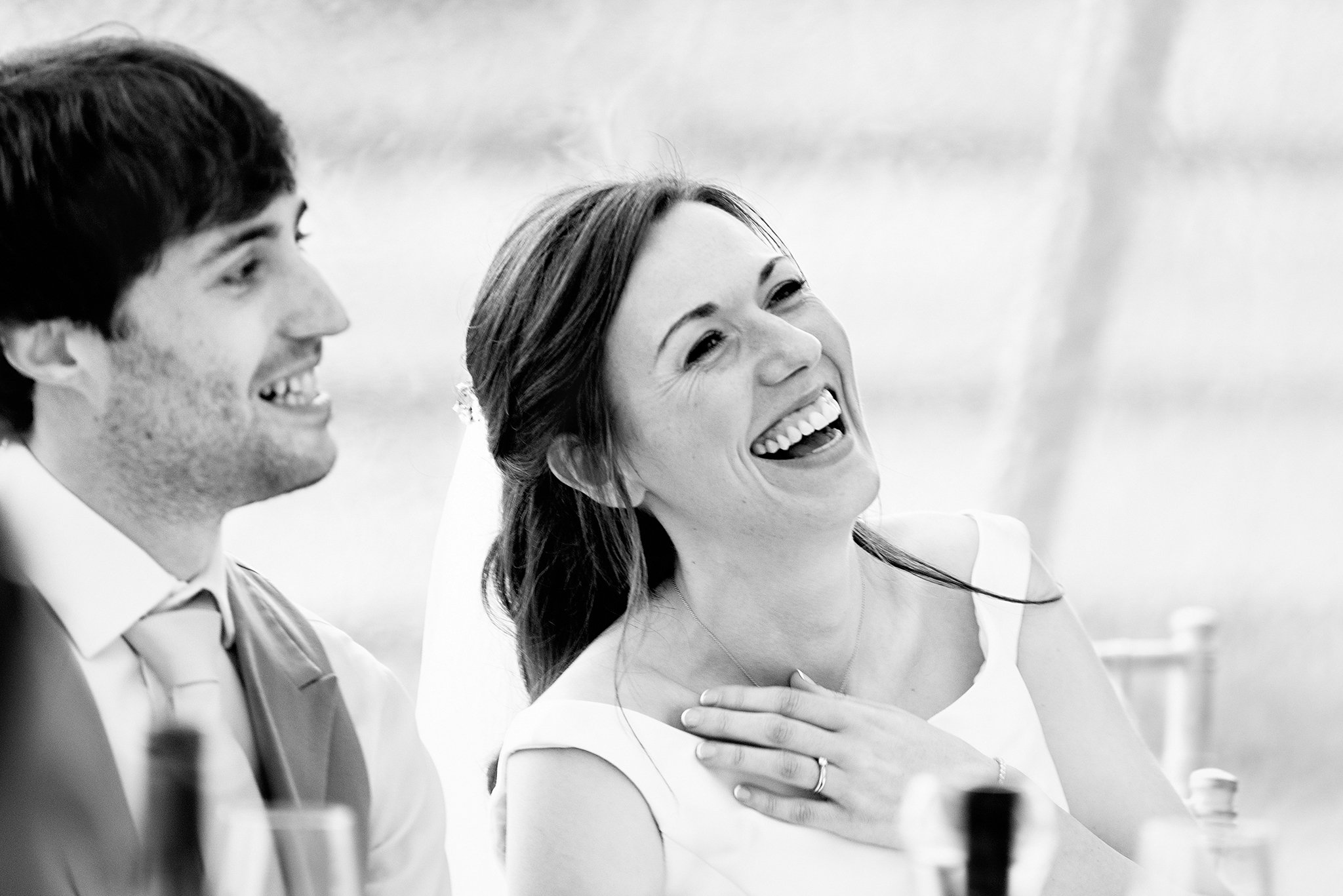 A bride laughs during wedding speeches 
