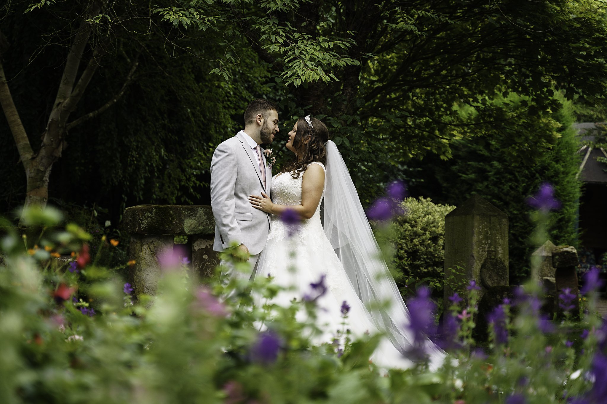  A bride and groom pose together in the gardens of the Hundred House Hotel in Shropshire, after their wedding 