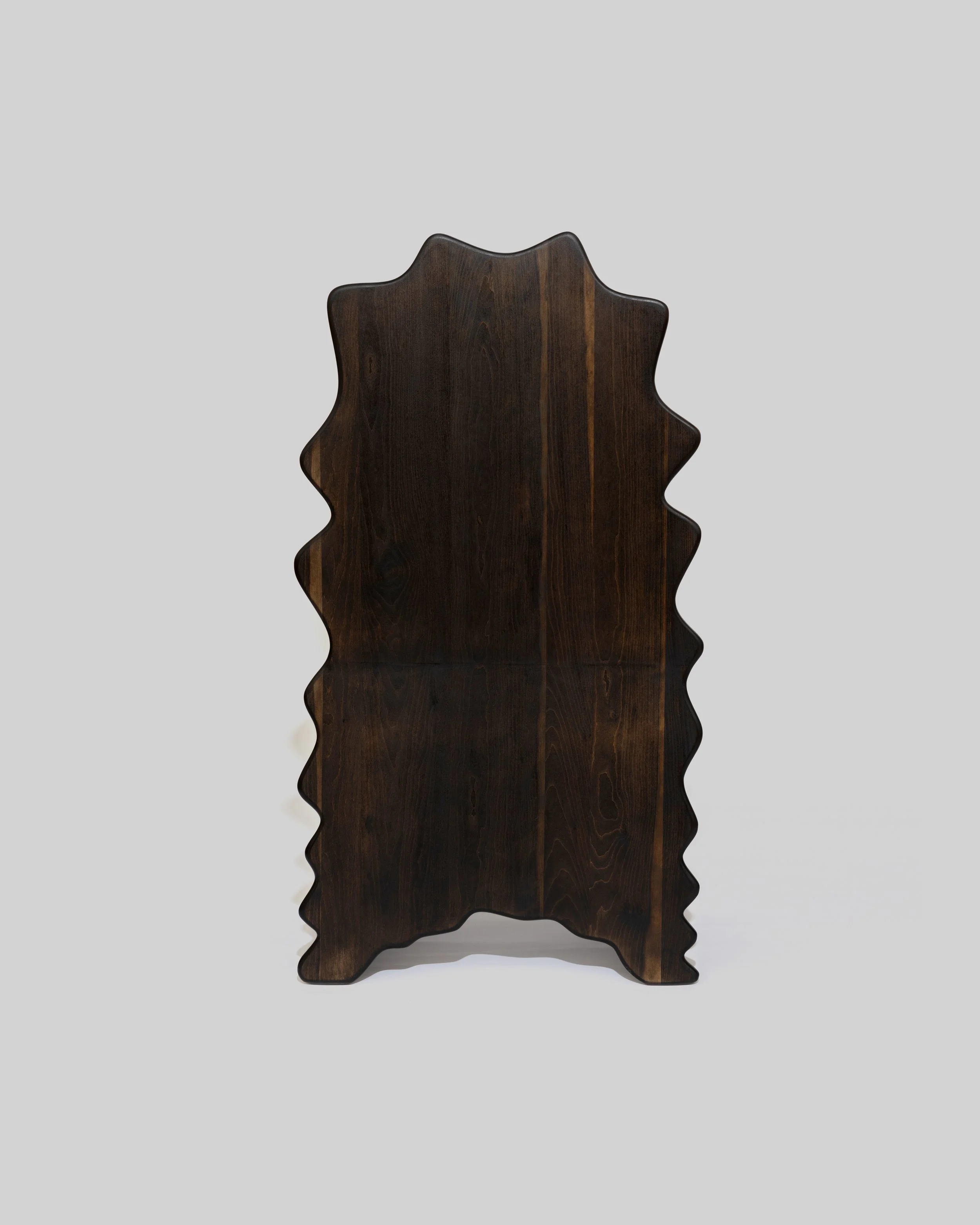 A dark brown wooden chair with a backrest in the shape of a maple leaf, set against a light gray background.