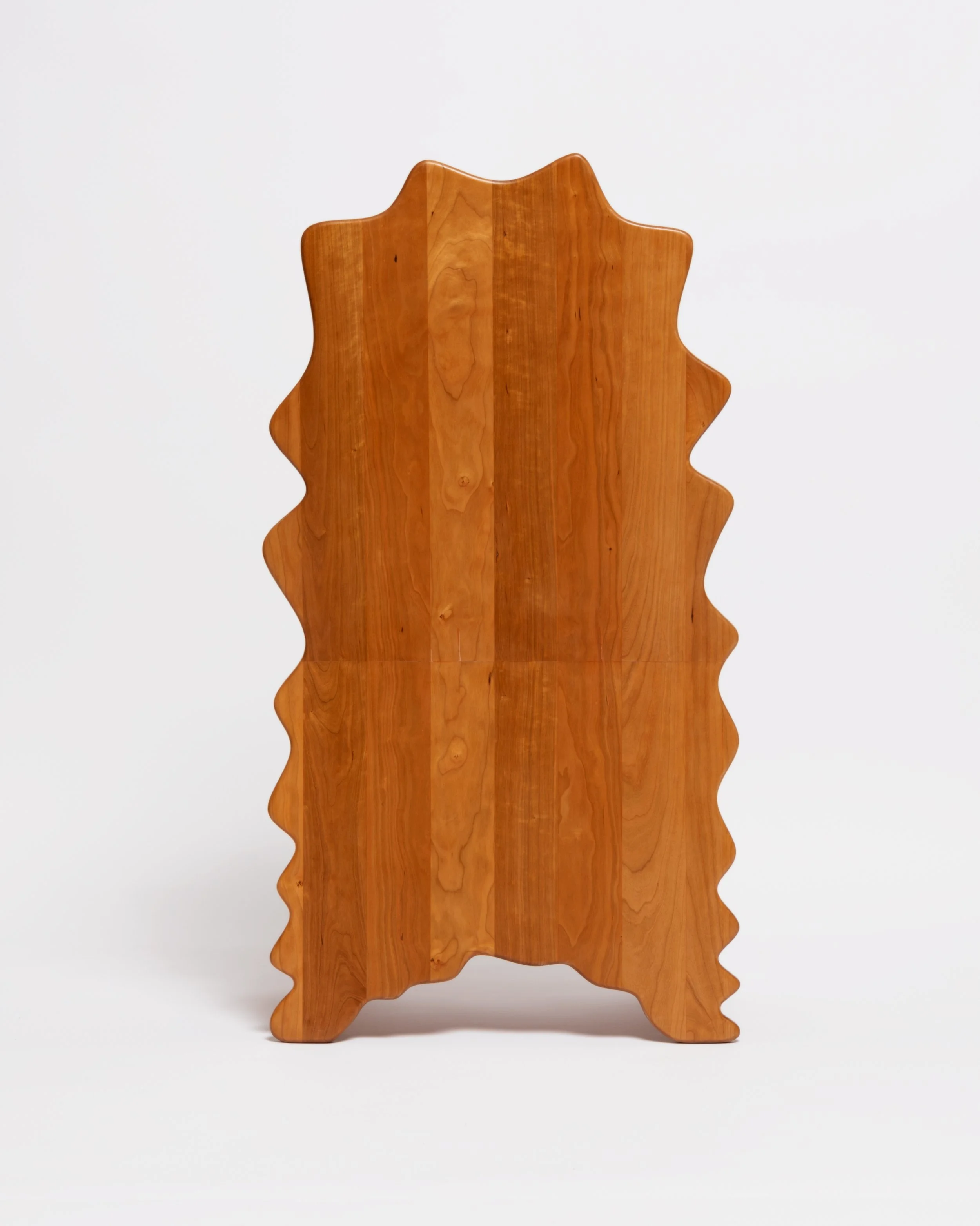 Wooden chair with a wavy, scalloped edges design placed against a plain white background.