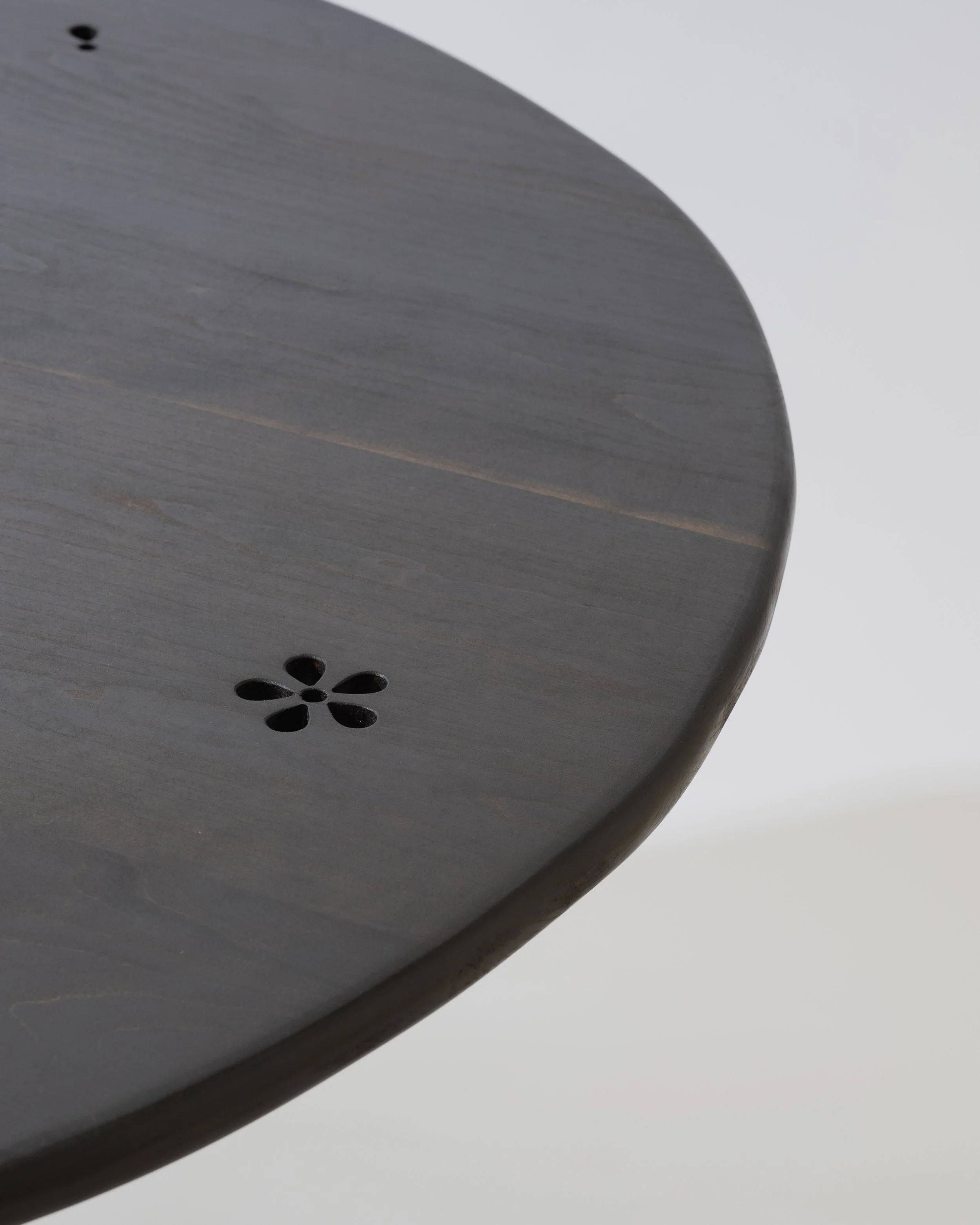 Close-up of a gray wooden surface with flower-shaped ventilation holes.