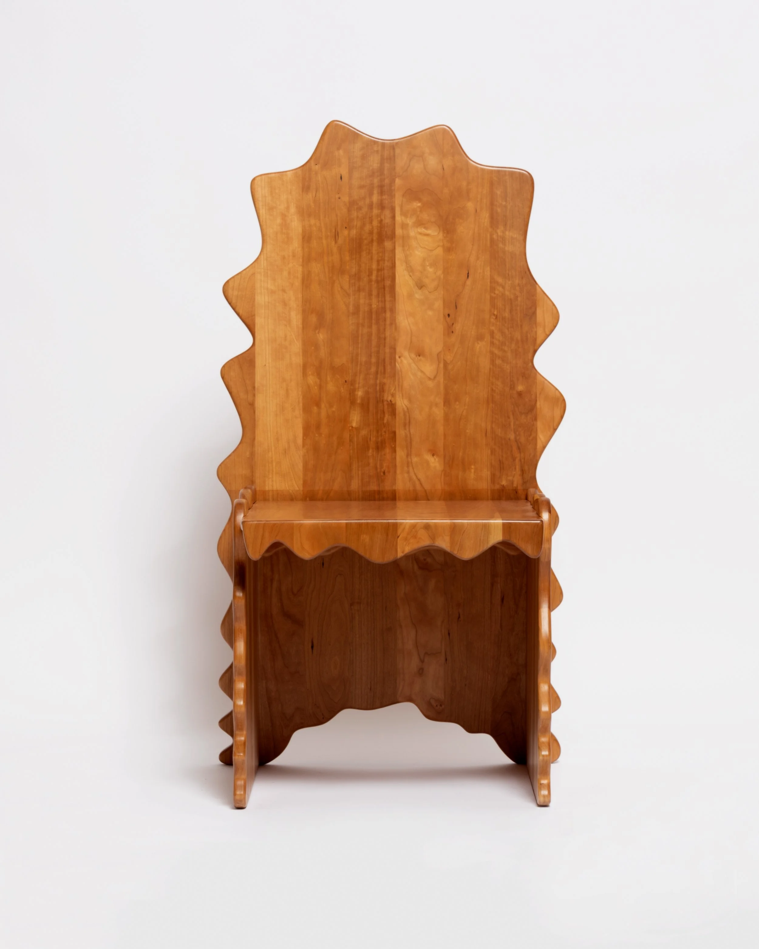 A wooden chair with a high, decorative backrest against a plain white background.
