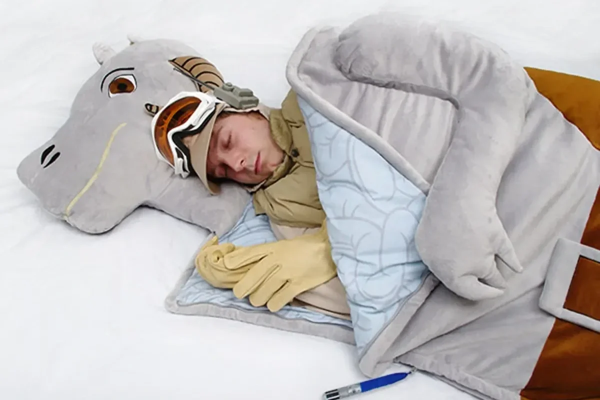 Man sleeping inside a ThinkGeek's star wars themed tauntaun sleeping bag