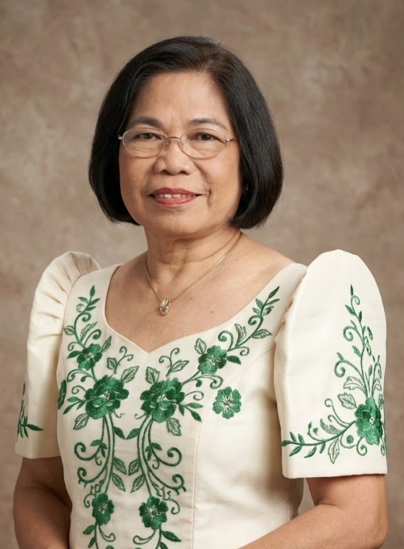 A woman with shoulder-length dark hair wearing glasses, a white dress with green floral embroidery, and a silver necklace, standing against a neutral background.