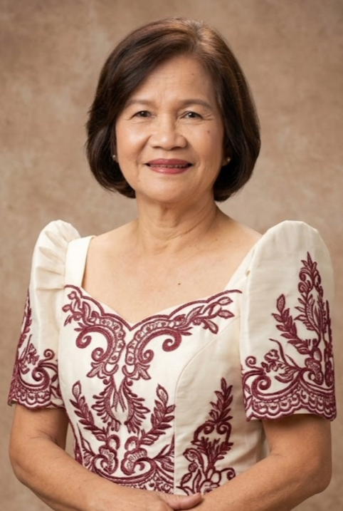 smiling woman with short dark hair wearing a white blouse with maroon embroidery, against a plain brown background