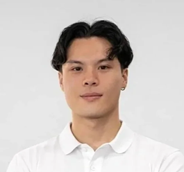 A man with slight curly hair wearing a collared white shirt smiling