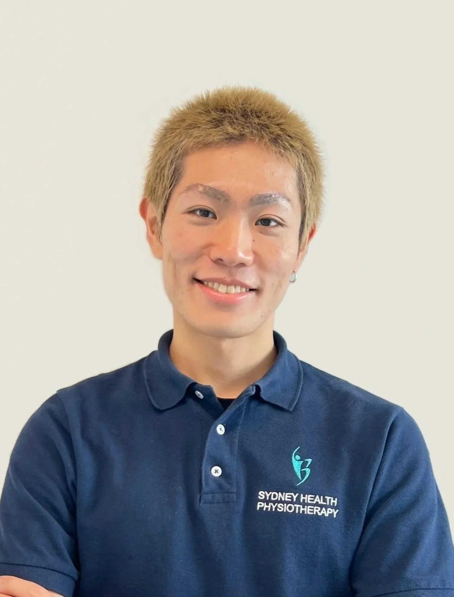 Slim asian man with dyed hair smiling