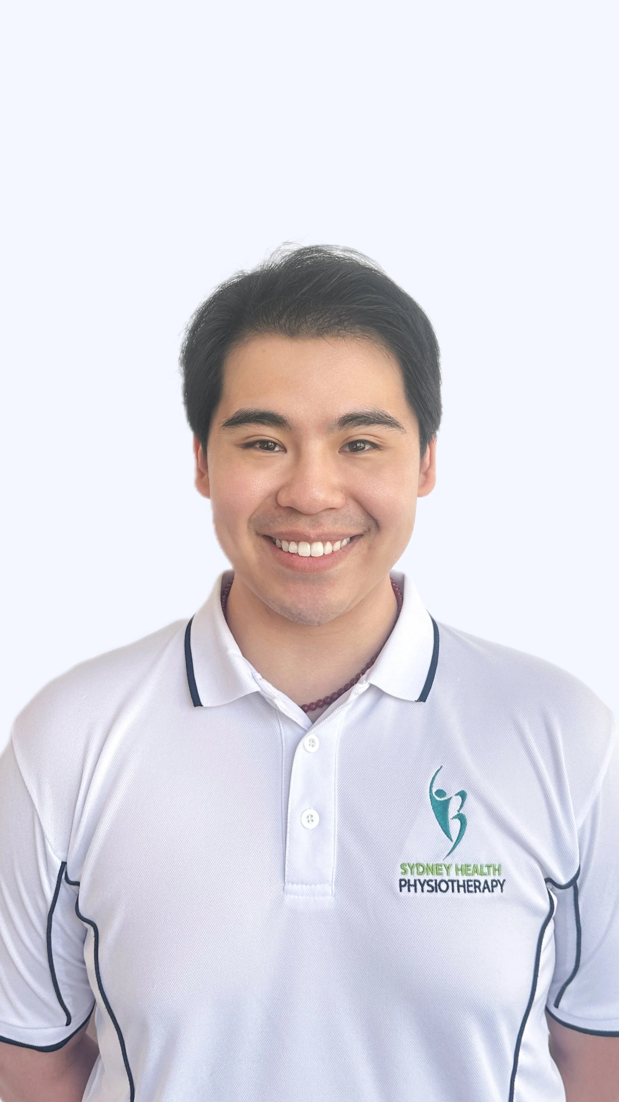 Black hair therapist in white polo smiling with teeth showing