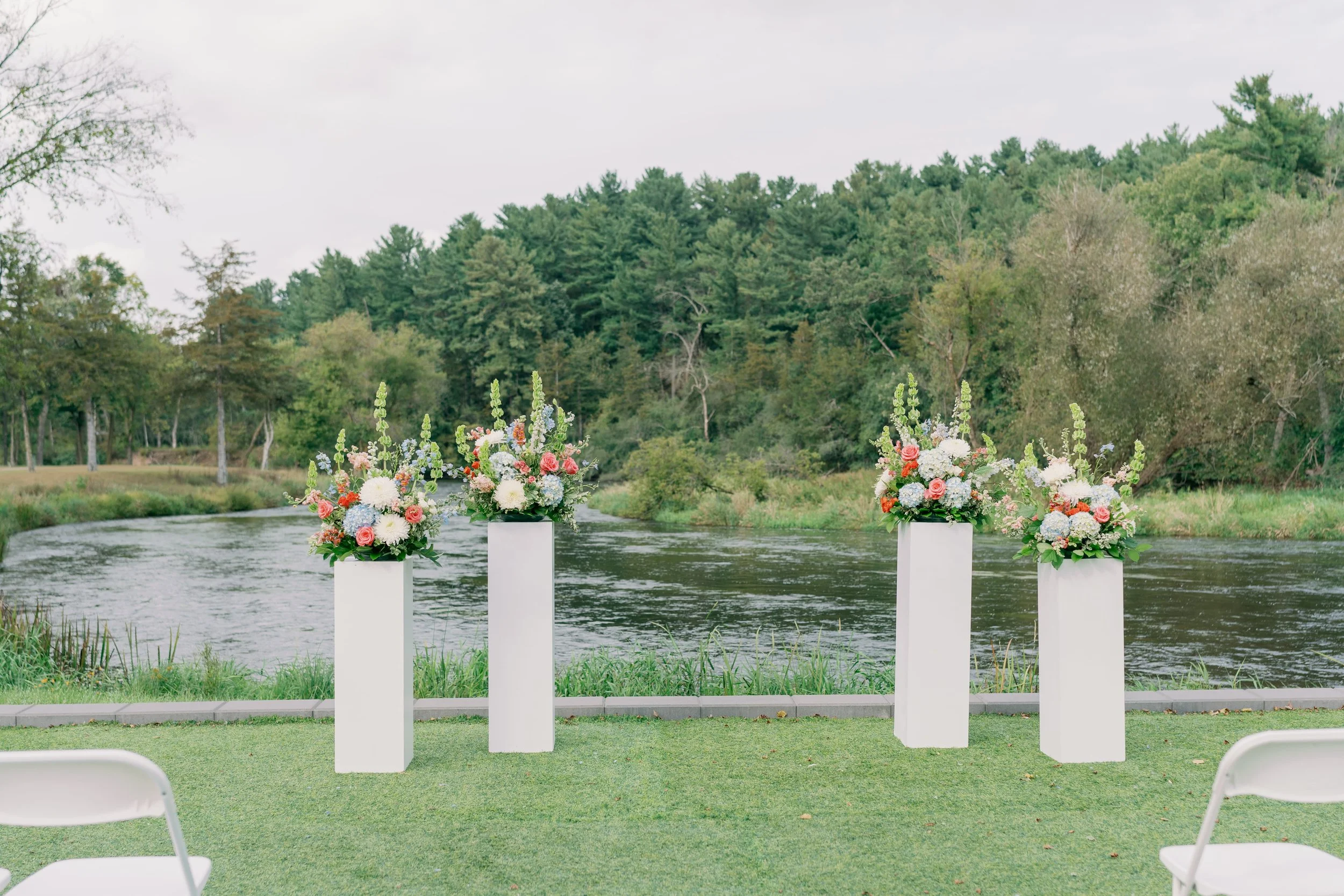 Ceremony florals in front of the river at La Pointe Events