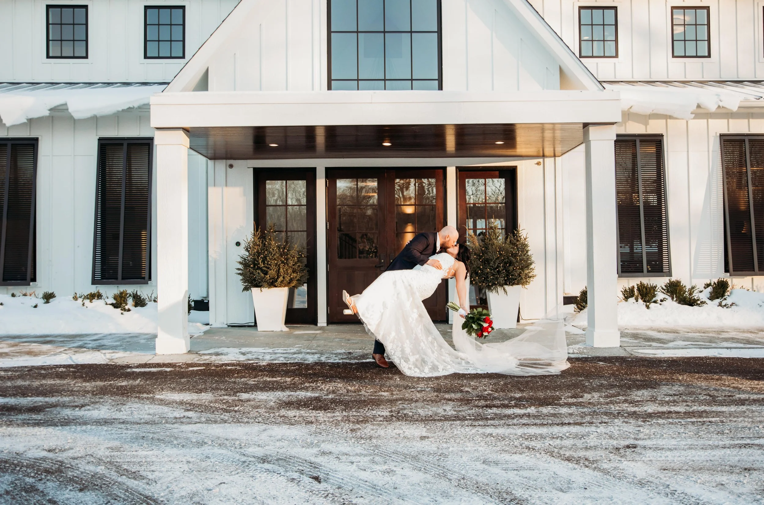 Newlyweds kiss outside of the Hutton House at their Minnesota Winter wedding.