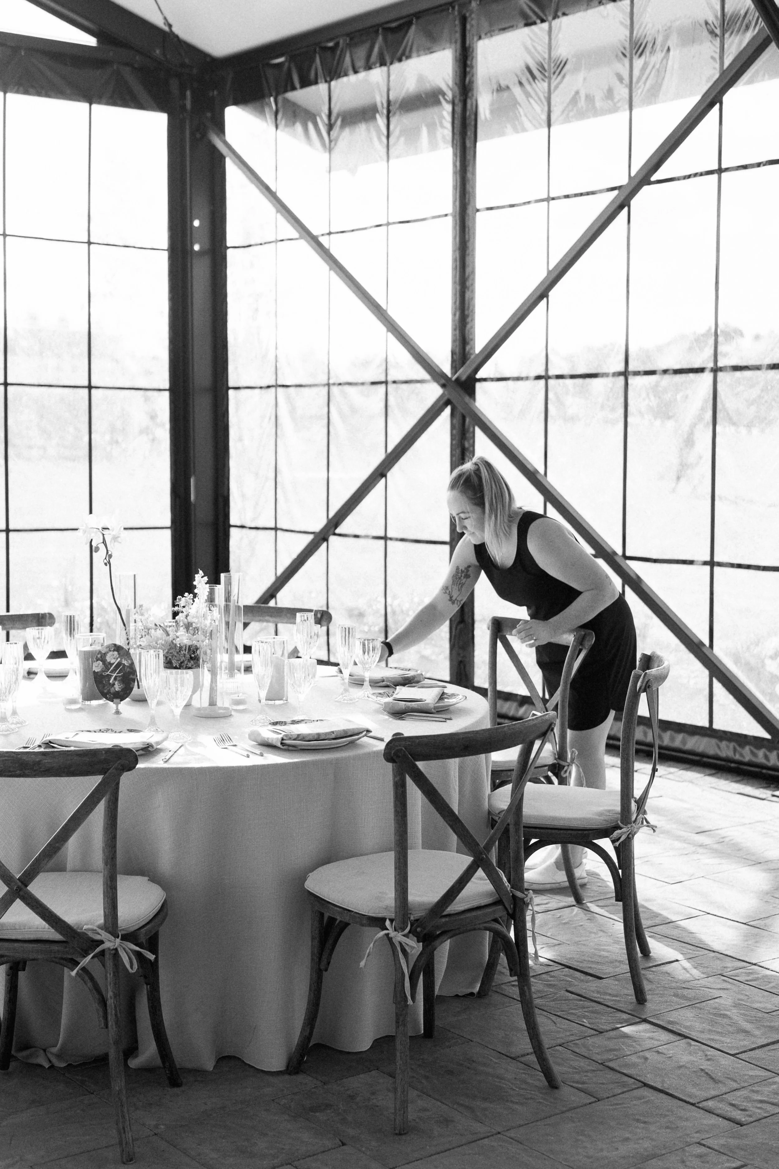 Minnesota wedding planner setting up at a wedding editorial at Rustic Roots Winery, a luxury Minnesota wedding venue in black and white.