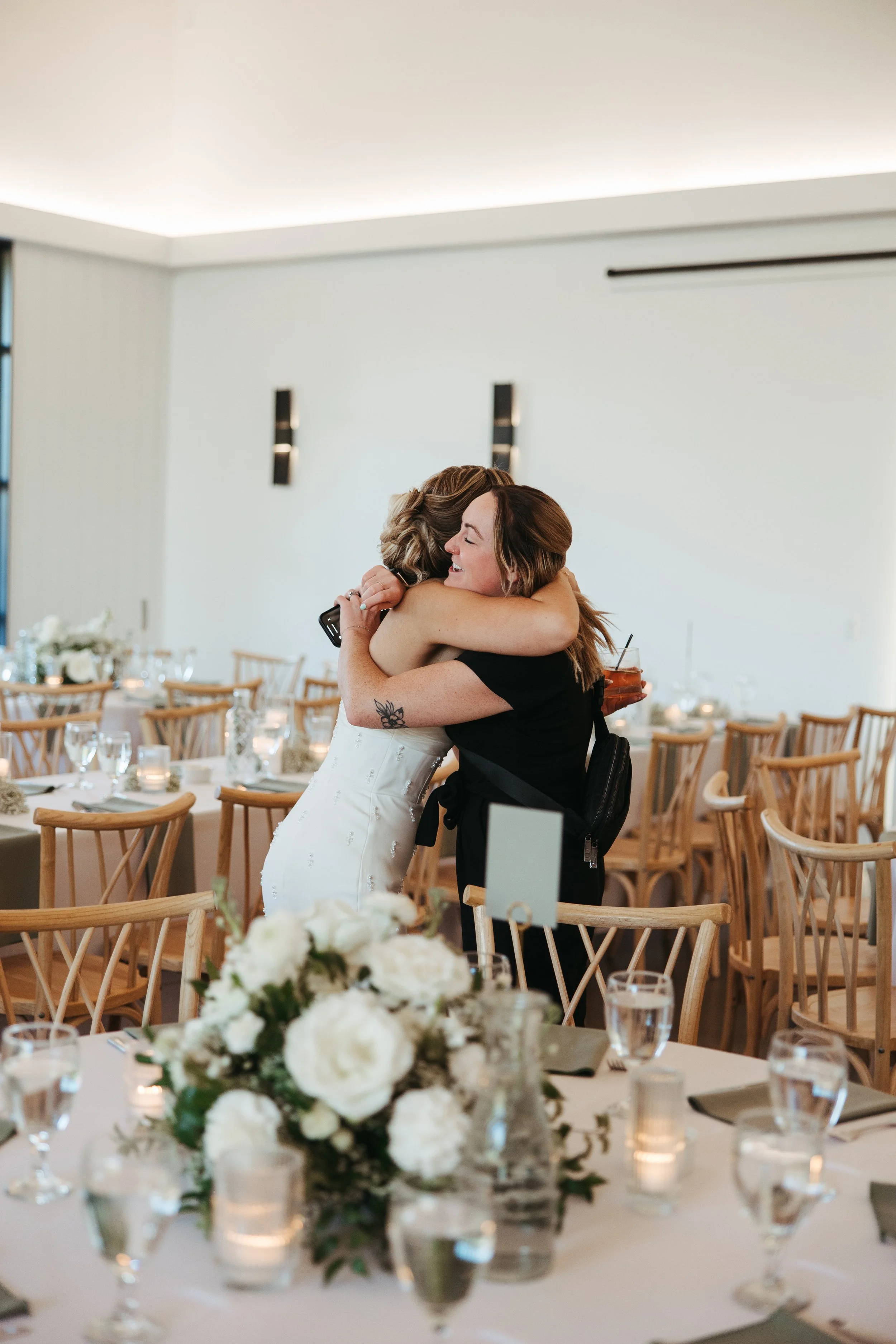 Minnesota wedding planner hugs a very happy bride during the reception at White & Sable in Minnesota.