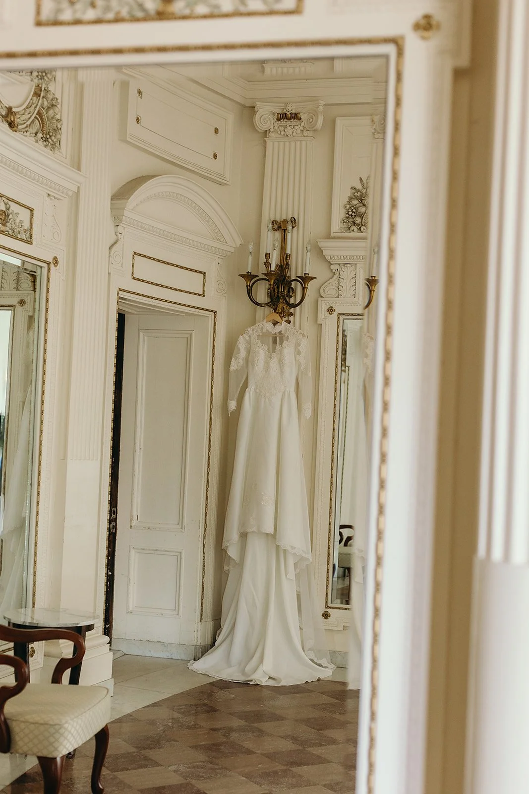 Wedding day details highlighting the historic architecture of Tupper Manor, including the brides wedding gown hanging from the wall 
