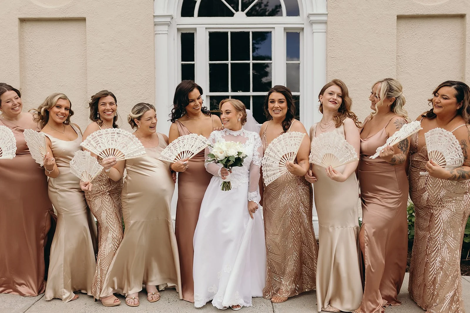 Bridesmaids in satin gowns in various shades of chamapgne and blush, for a wedding at Tupper Manor