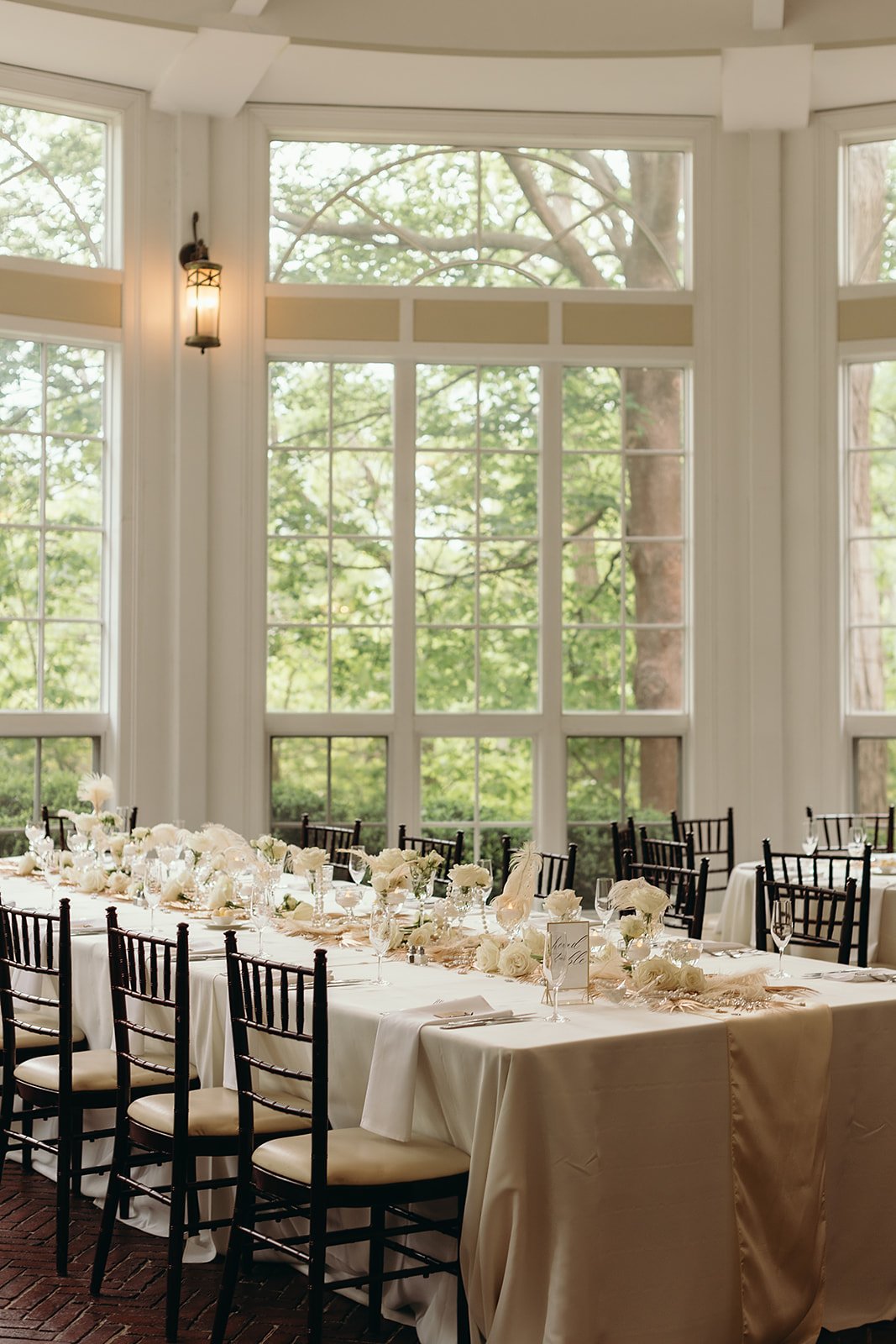 A vintage art deco inspired wedding reception at Tupper Manor, with gold feather table runners, pearls, white roses, crystals and candles