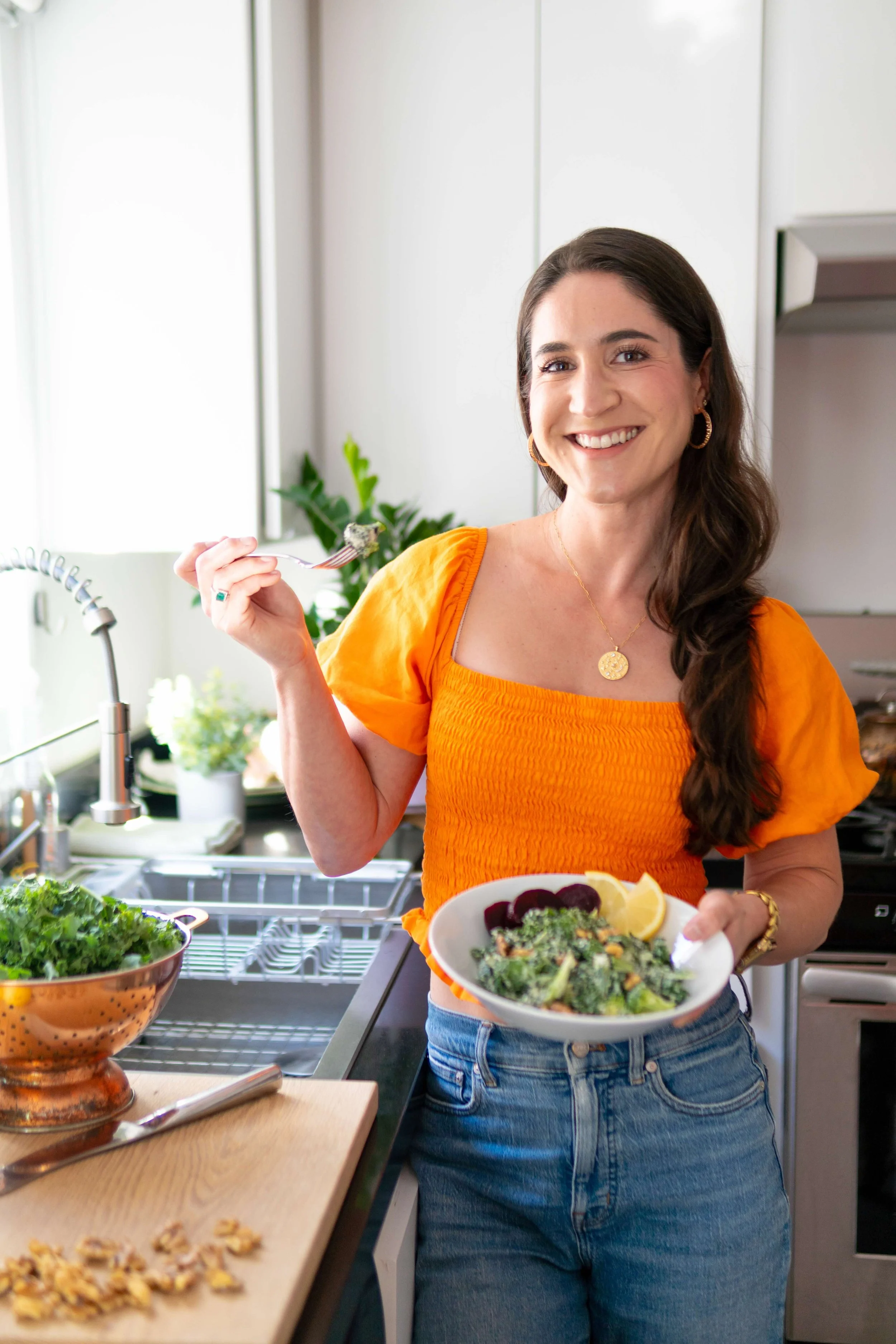 woman fertility nutrition coach in a kitchen holding a salad