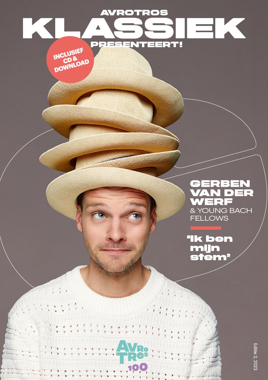 Poster advertising a concert by Gerben Van Der Werf & Young Bach Fellows, featuring a man with blue eyes wearing a white knitted sweater and a tower of floppy hats on his head, with text in Dutch about a compilation album including a CD and download.