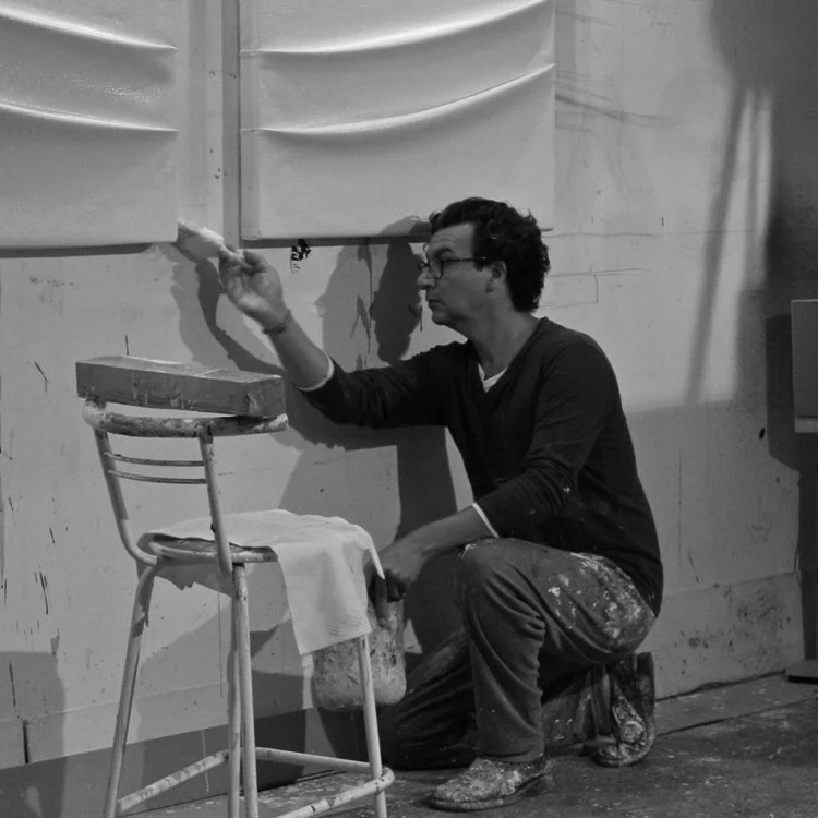 Fernando Cuétara (born 1969) is a self-taught artist, born and raised in Madrid, Spain. His inspiration comes from regularity, symmetry, minimalism, and harmony. His career path was everything but linear. He was a major component to his family business followed by a very challenging corporate career path. From there, he went onto exploring the world. Fernando Cuétara describes his work as very sensual and minimal. He uses manipulated fabrics, LED lights and acrylic. Currently he is even experimenting with coffee. The artist finds joy in experimenting with wood, angles and textures, his current goal is to make the actual canvas disappear all together. His biography describes him as a nineteenth century artisan. For Fernando Cuétara, the folding technique he uses is the key to the composition of his paintings, that’s where matter and soul meet.