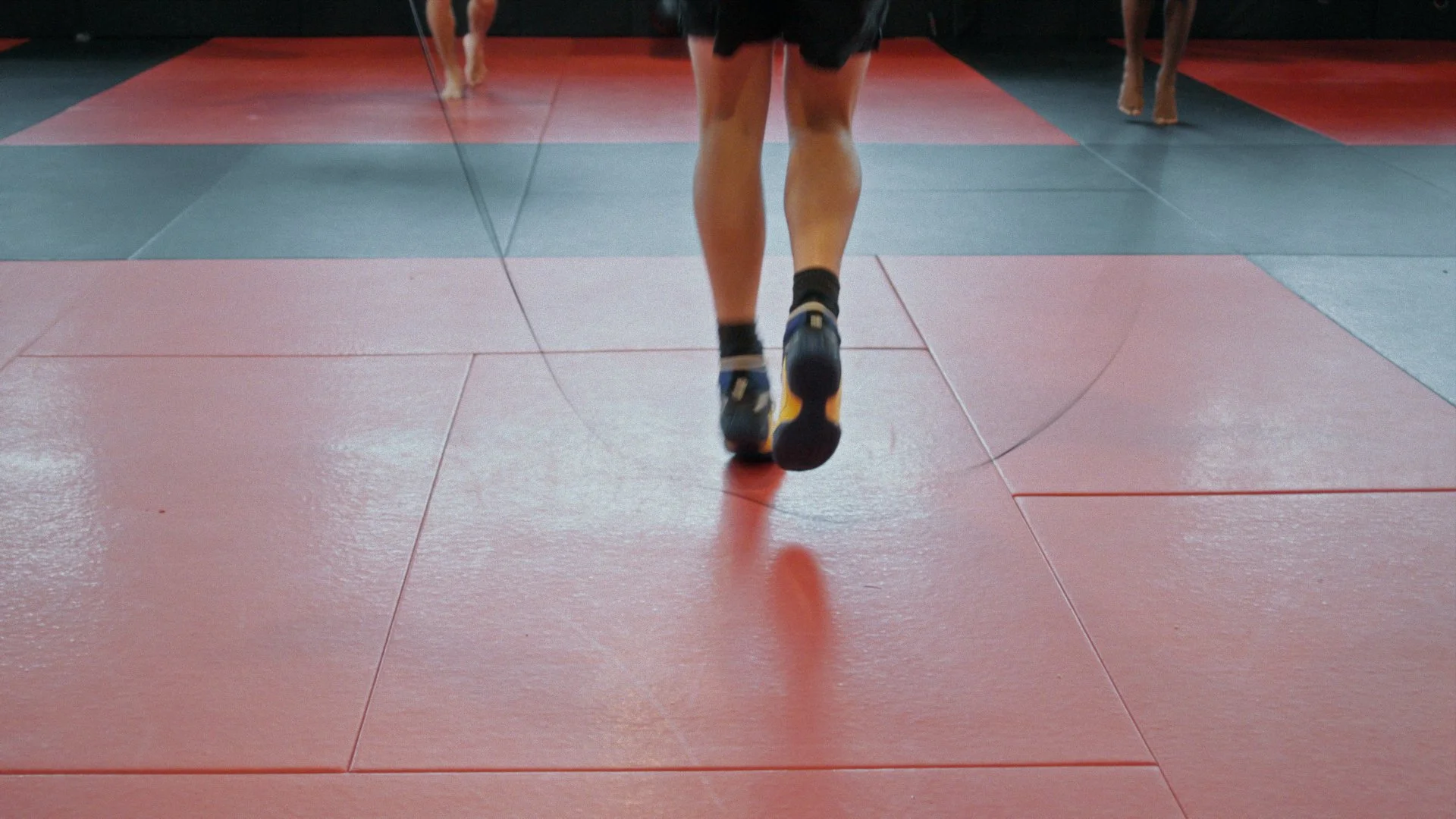Close-up of an MMA fighter's feet on the mat jump roping  still from a Passenger Productions athletics documentary for Chey Bowers and Next Edge Academy