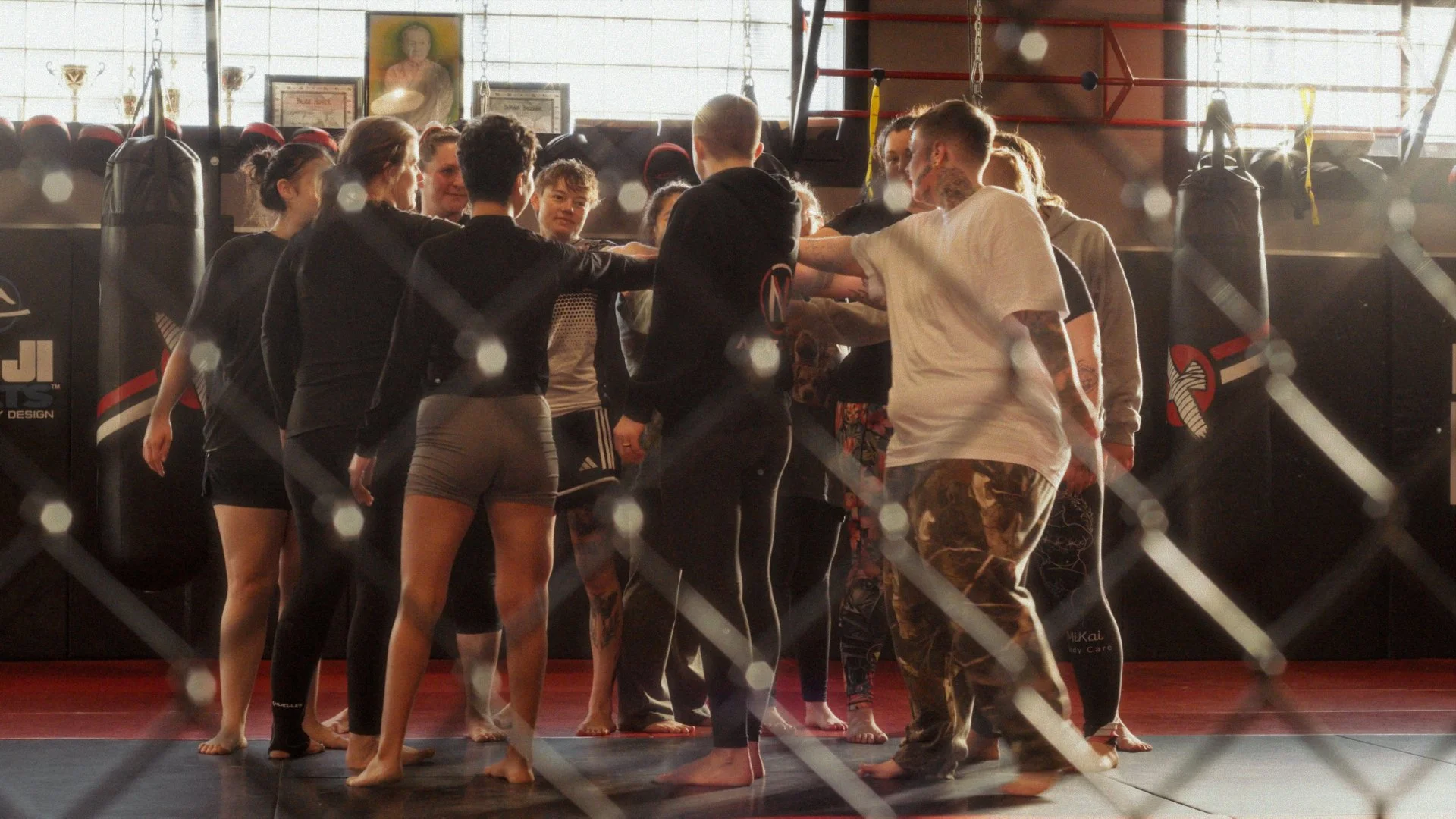 MMA students gathered in a team huddle at Next Edge Academy, still from a Passenger Productions athletics documentary about Chey Bowers