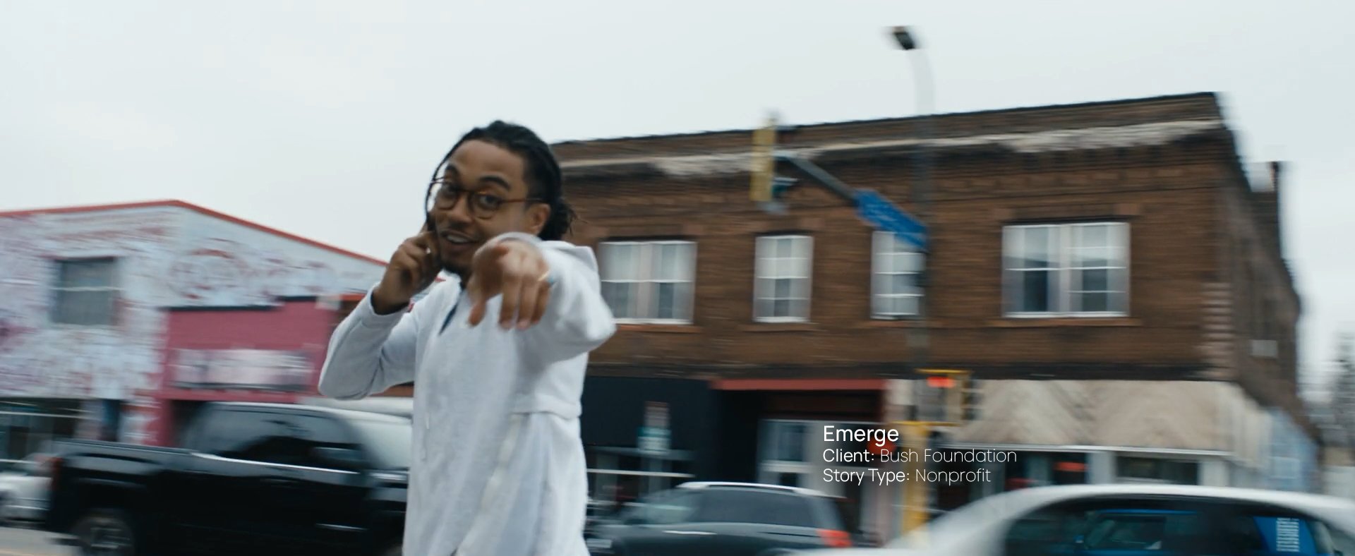 Man on a phone pointing toward the camera on a city street, still from a Passenger Productions nonprofit documentary for the Bush Foundation