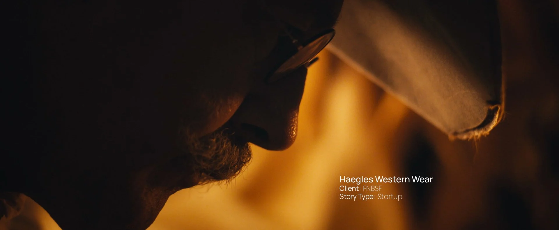 Close-up profile portrait lit in warm tones, still from a Passenger Productions startup documentary for Haegles Western Wear and First National Bank in Sioux Falls