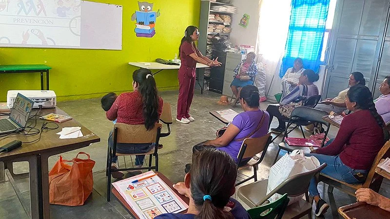 Woman giving instruction in a classroom full of people